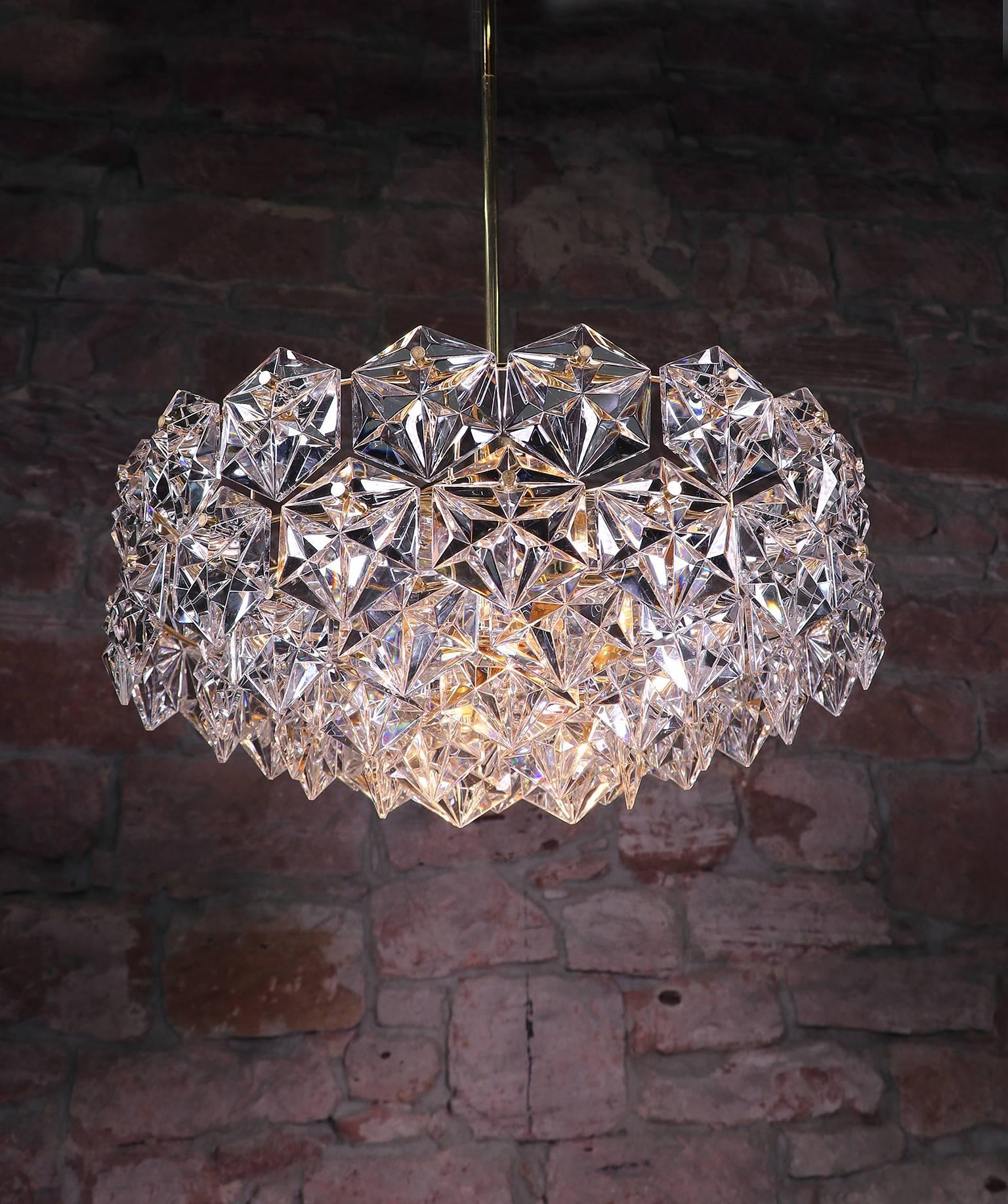 Elegant large five-tier chandelier with faceted crystals on a gold-plated brass frame. Manufactured by Kinkeldey, Germany, in the 1960s.

Adjustability: the rod is divided and can be adjusted as required for greater or lesser drop. 
Lighting: takes