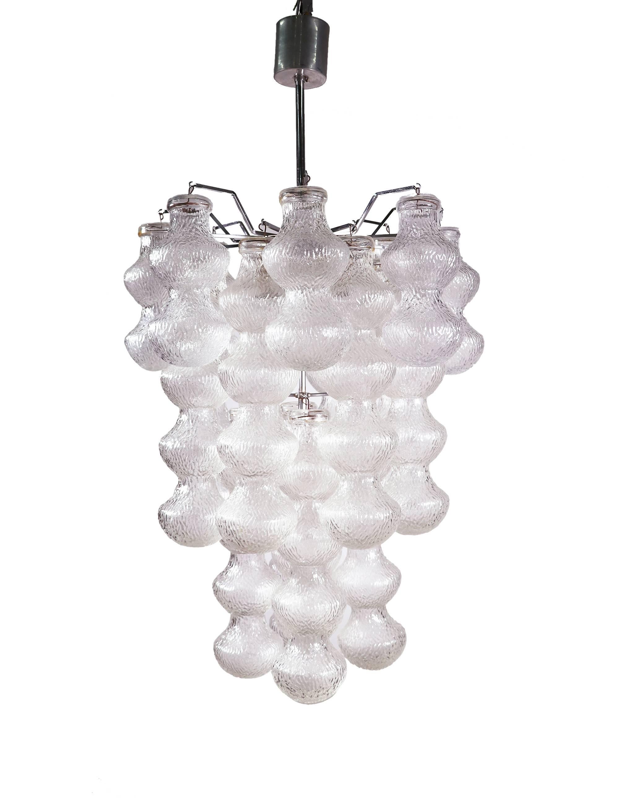 Elegant lustre à plusieurs niveaux avec des tubes en verre soufflé texturé de Murano suspendus à une suspension en forme d'araignée chromée. Le lustre éclaire magnifiquement et offre beaucoup de lumière. Gemme de l'époque. Avec ce luminaire, vous