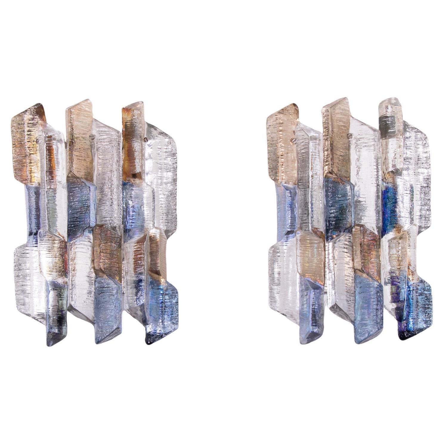 Elegantes Paar mehrfarbiger Wandleuchten aus Murano-Glas, entworfen von J.T. Kalmar besteht aus sechs strukturierten, klaren Glaselementen mit blauer, bernsteinfarbener und klarer Tönung, die auf einer vernickelten Rückwand aufgehängt sind.