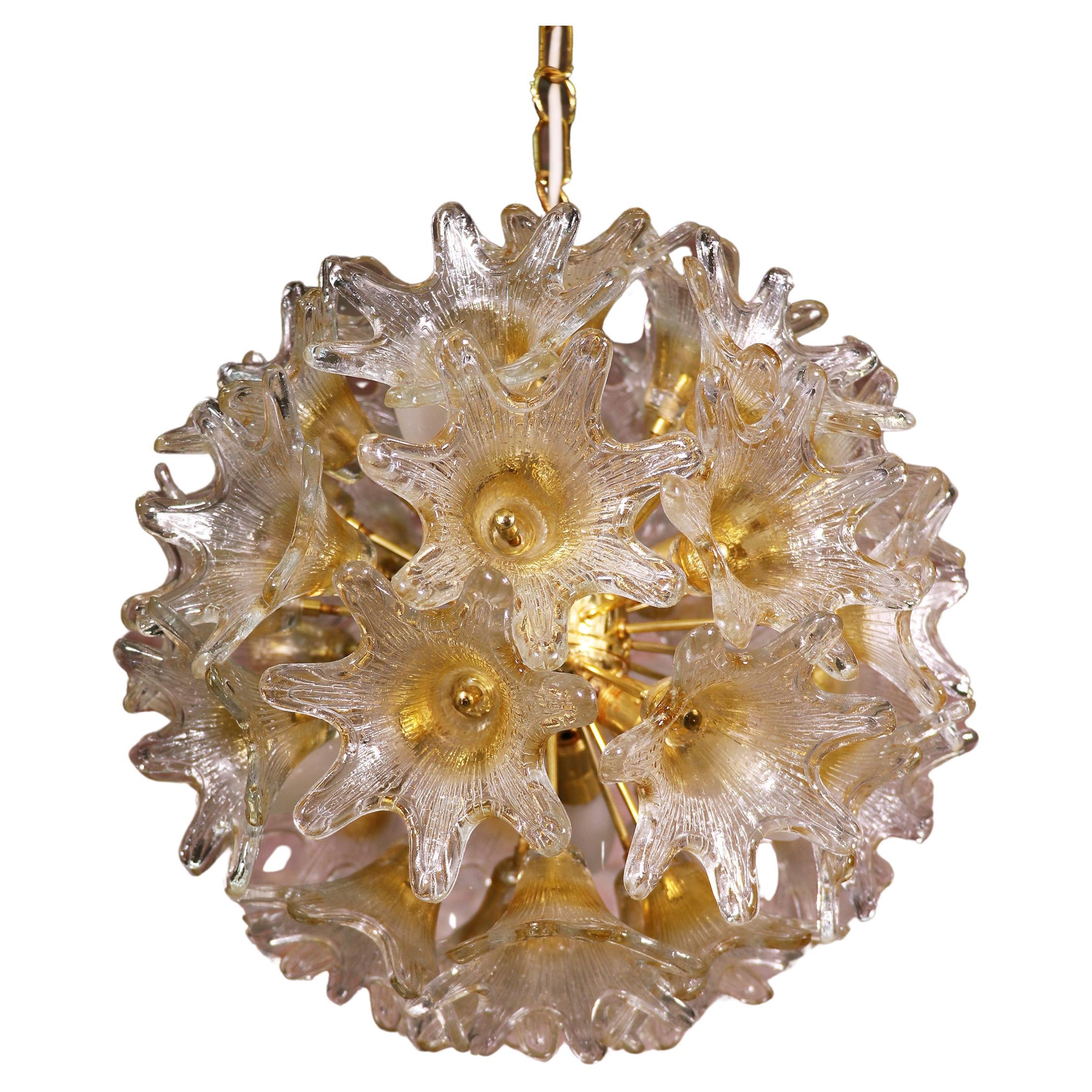 Elegant sputnik chandelier with star-shaped amber Murano glass flowers on a gilded brass frame. Designed by Paolo Venini. Star-shaped glasses resembles flowers. Chandelier illuminates beautifully and offers a lot of light. Manufactured by Venini for