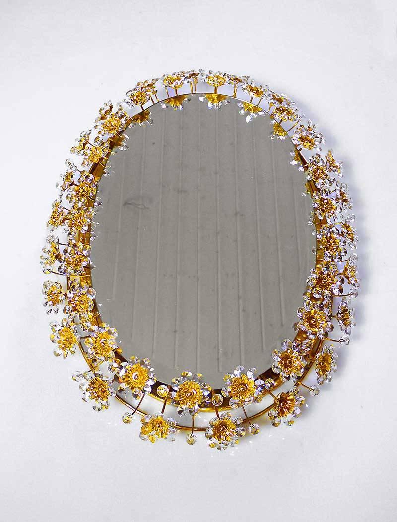 Elegant illuminated oval backlit mirror with faceted crystals forming petals and flowers on a gilded brass frame. Desinged by Christoph Palme. Manufactured by Palwa, Germany, 1960s. 

Design: Christoph Palme. 
Model: Sputnik Mirror. 
Execution: