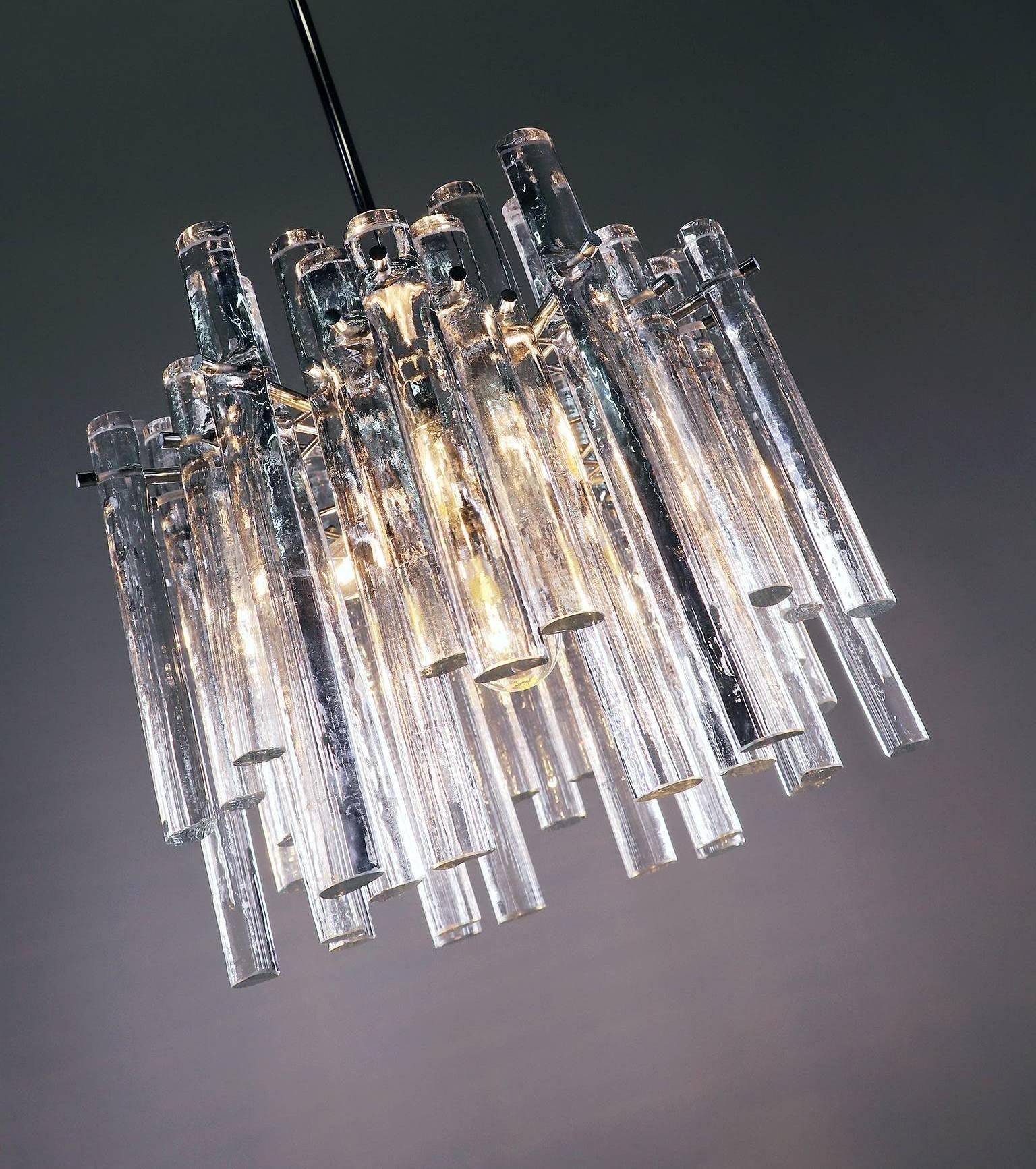 Elegant chandelier with crystal glass rods like iced sticks of various lengths on a chrome metal frame. Manufactured by Kinkeldey, Germany in the 1960s. 

Adjustability: the bar is divided and can be adjusted as required for greater or lesser drop.