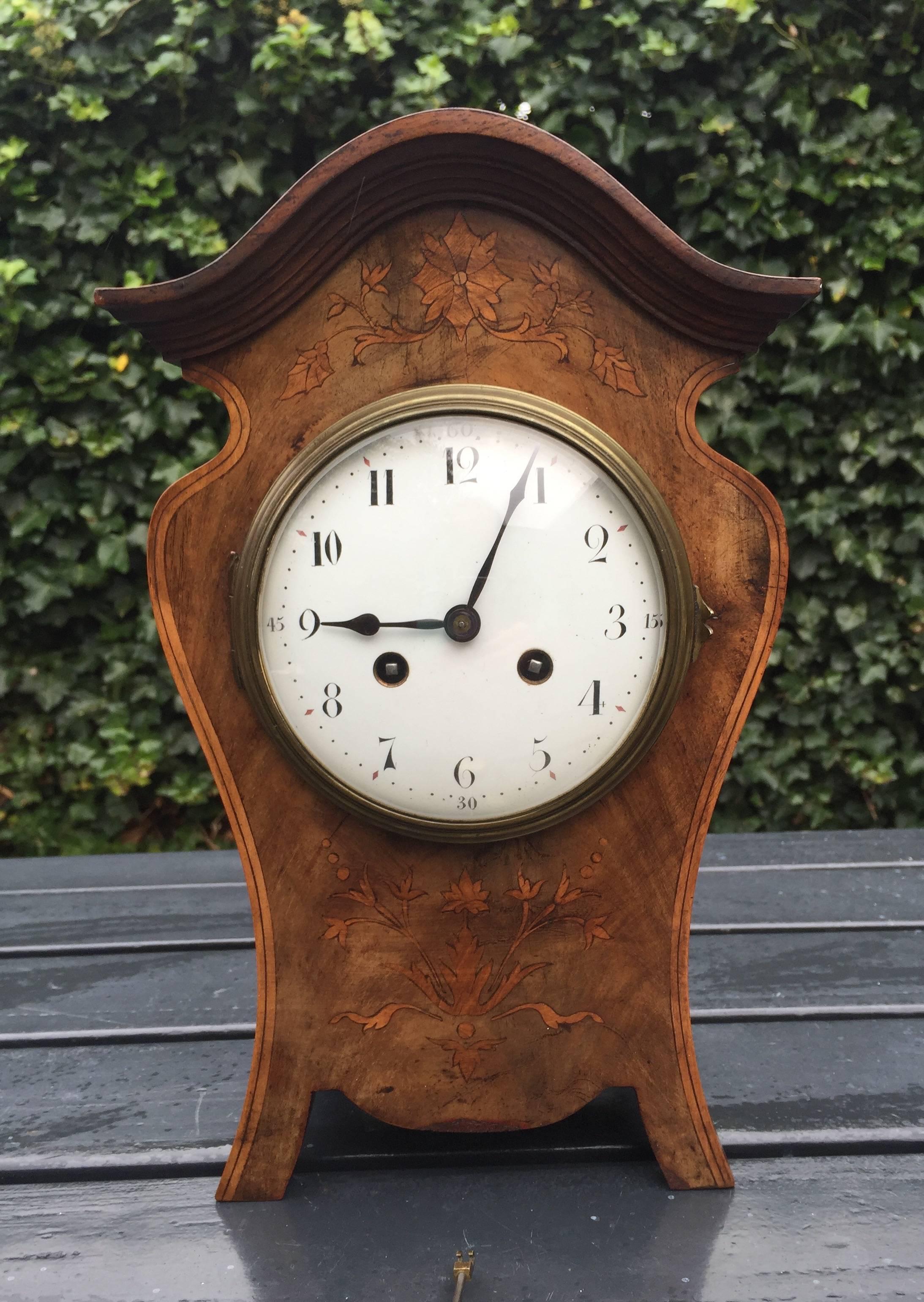 Stylish Art Nouveau clock in good working order. 

This stunning Art Nouveau clock has a beautiful patina and a clean and clear dial face with a curved glass door in front. This Fine mantel clock has wonderful, natural grain motifs of the quality