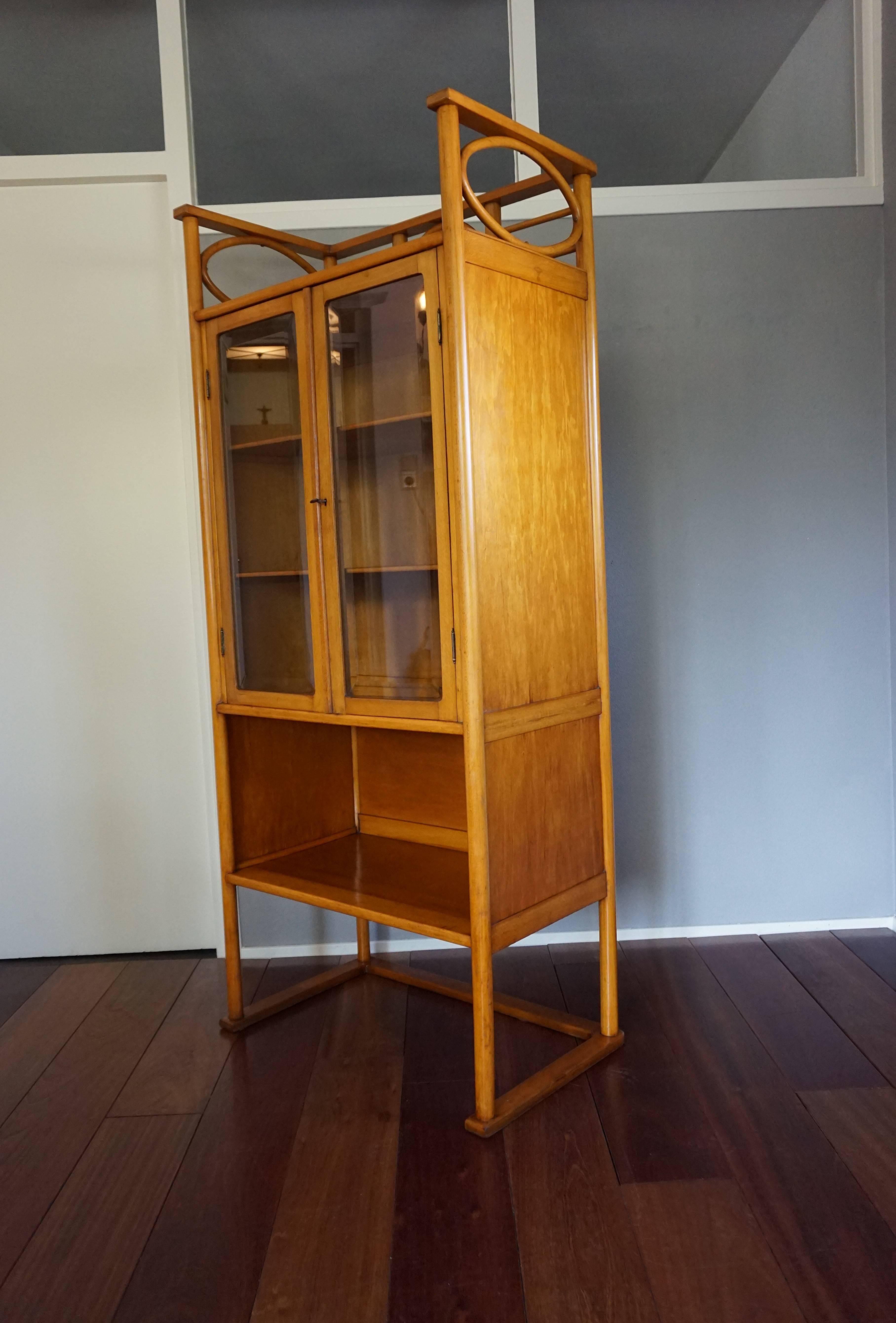 Stunning design and beautiful color, bentwood cabinet.

This antique and rare cabinet in the Thonet style can only have been made by one of the greats in the bentwood industry, but there are no maker's marks. This early 20th century design is still