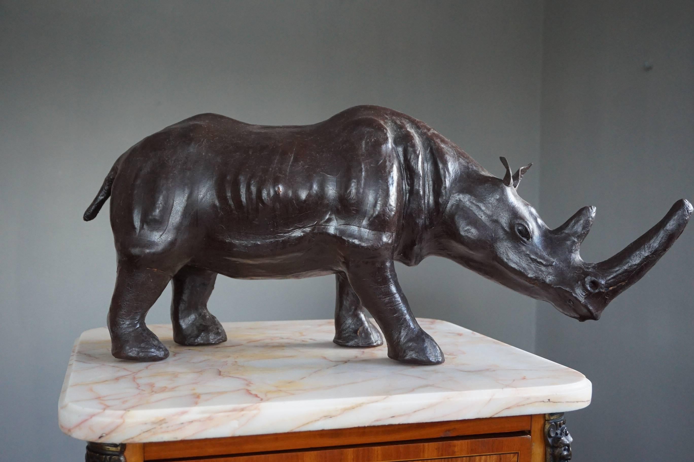 Good size and highly decorative rhinoceros sculpture.

This full-grown and impressive rhino has both great aesthetic and decorative value. Underneath the leather hide is a well carved wooden sculpture which is why this sizable rhino has such