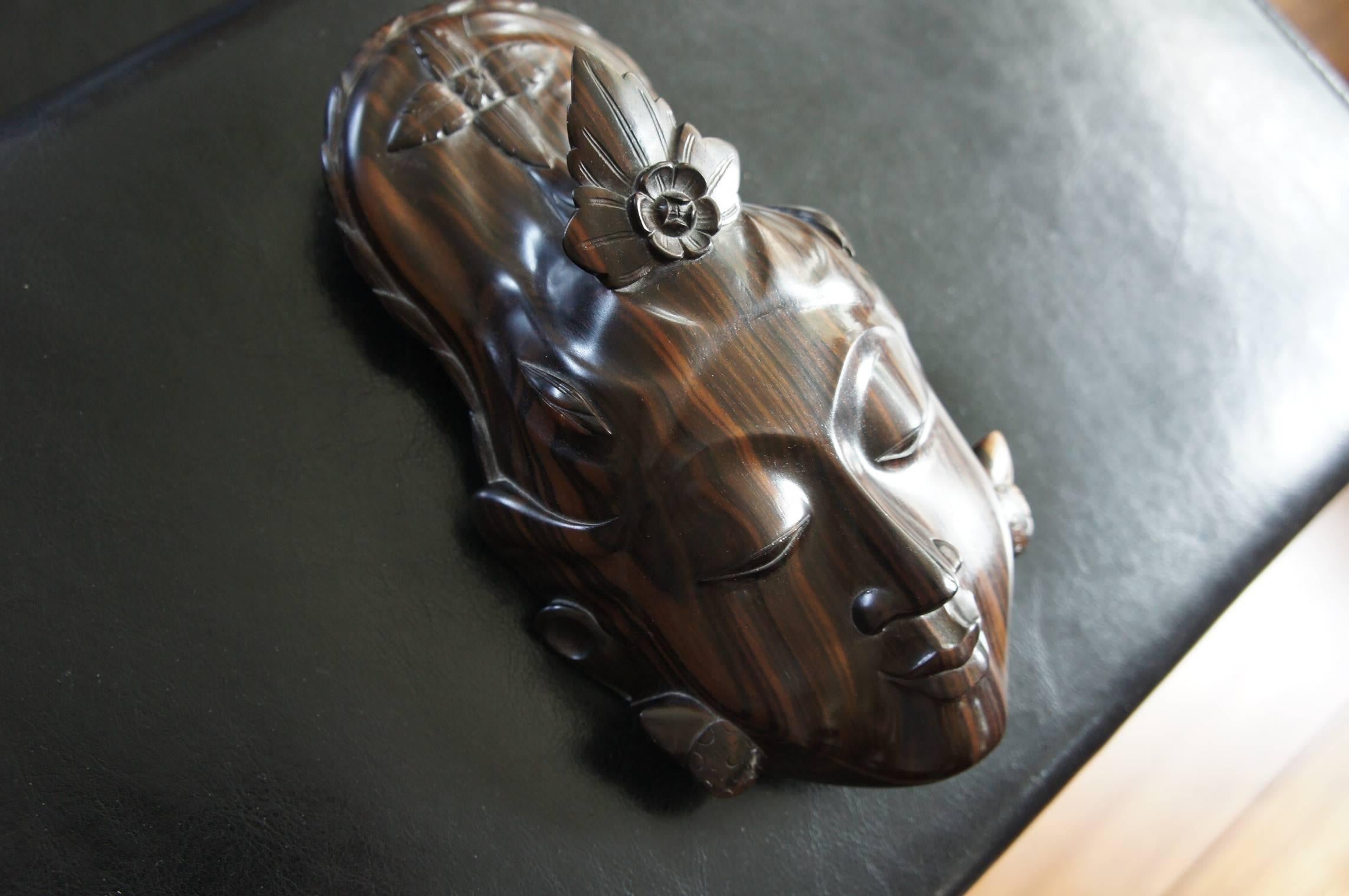 Atemberaubende & heitere Maske aus einer der teuersten Holzarten der Welt. 

Seit dem Embargo für das Abholzen von Makassar-Ebenholz ist der Preis für dieses schöne Holz in die Höhe geschossen. Der aktuelle Preis pro Kubikmeter dieses