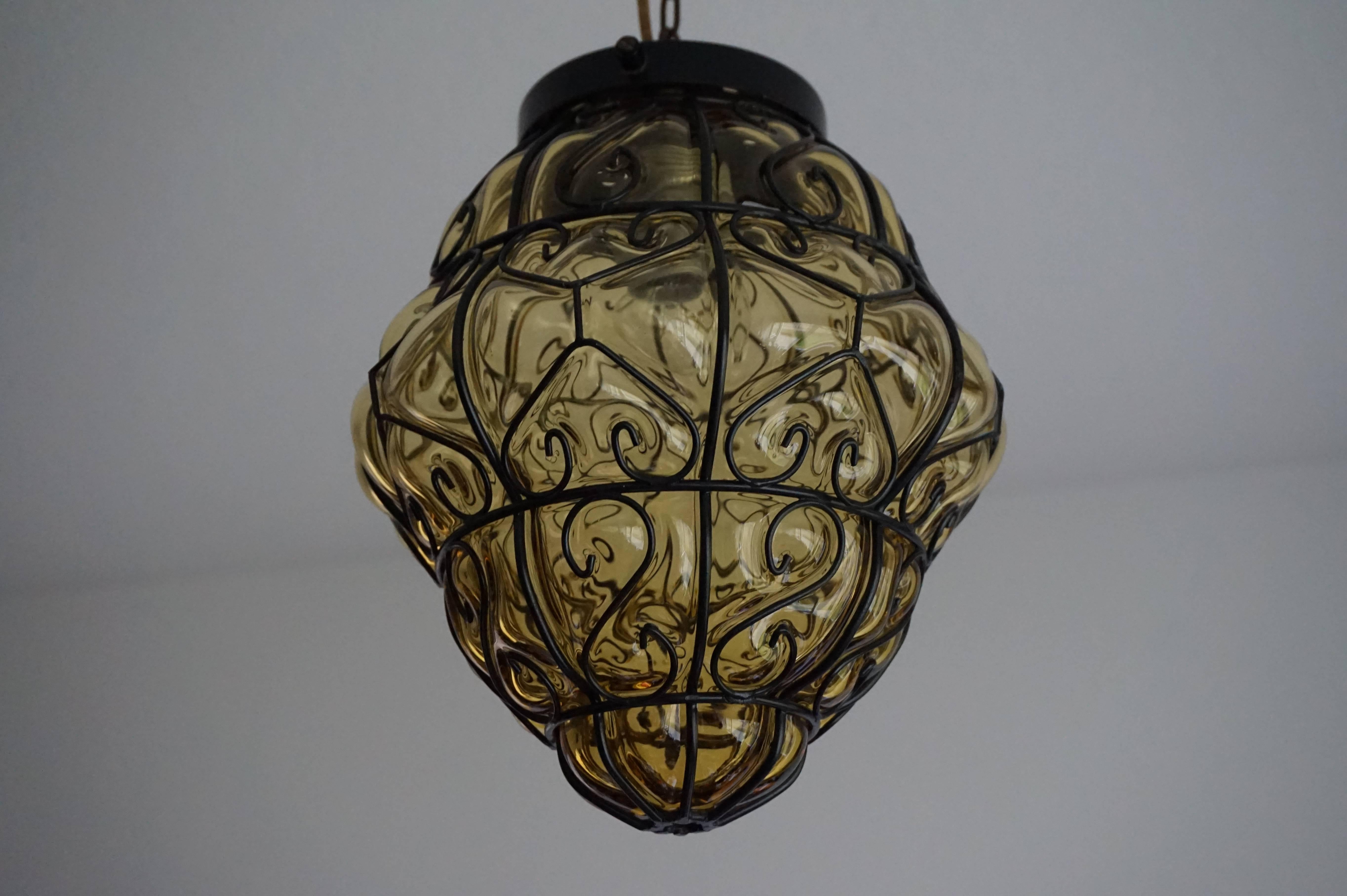 This little Venetian beauty is in mint condition.

This stunning, single light midcentury pendant is beautiful both in shape and color. It comes with the original chain and black metal canopy and the light bulb can easily be replaced by unscrewing