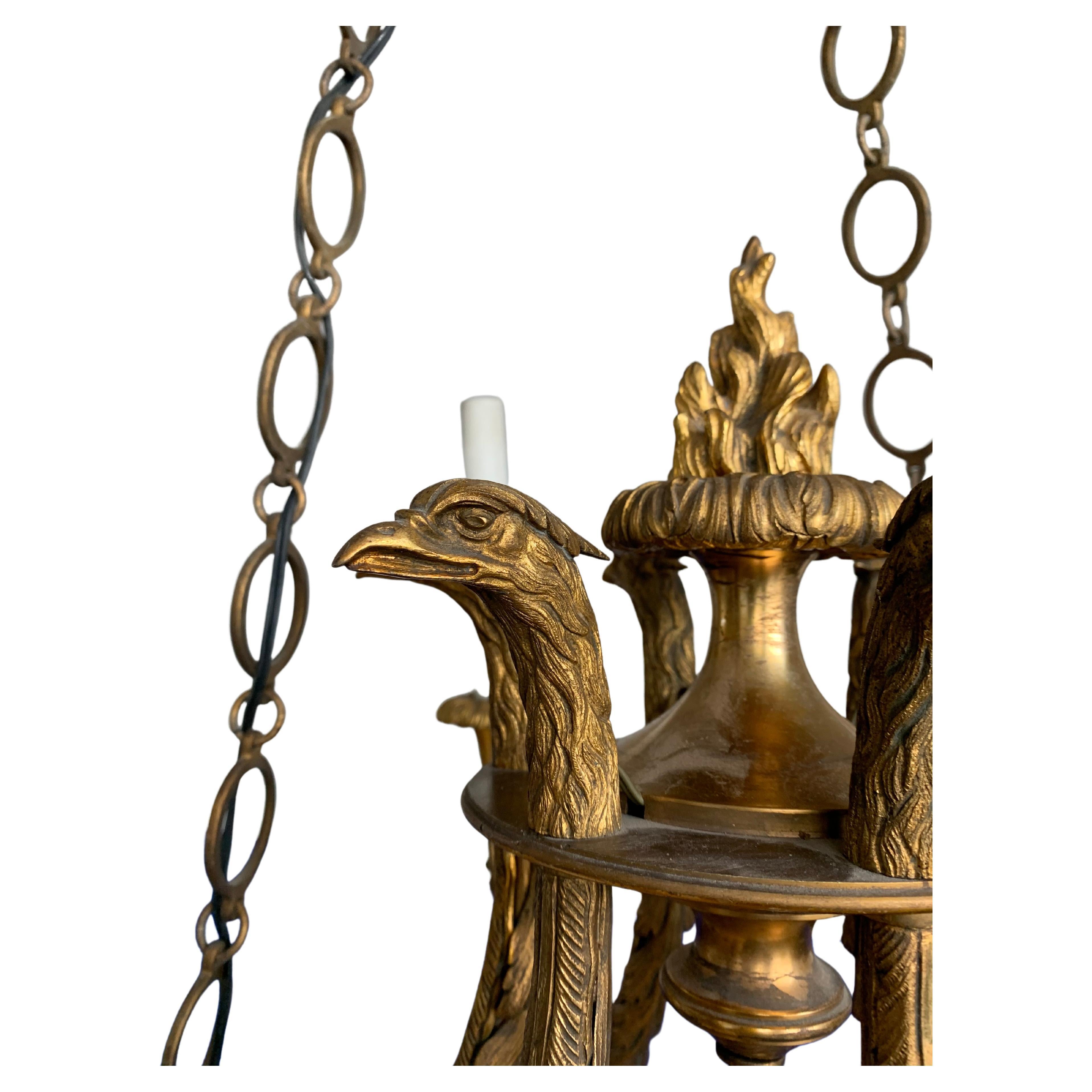 Stunning six-light chandelier with eternal flames urrounded by gilt bronze Eagle head sculptures. 

This unique chandelier is a truly stylish, well proportioned and top quality made work of lighting art from the turn of the century. If you have an