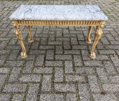 Tavolino in stile egizio revival, in legno intagliato, con piano in marmo e gambe figurative