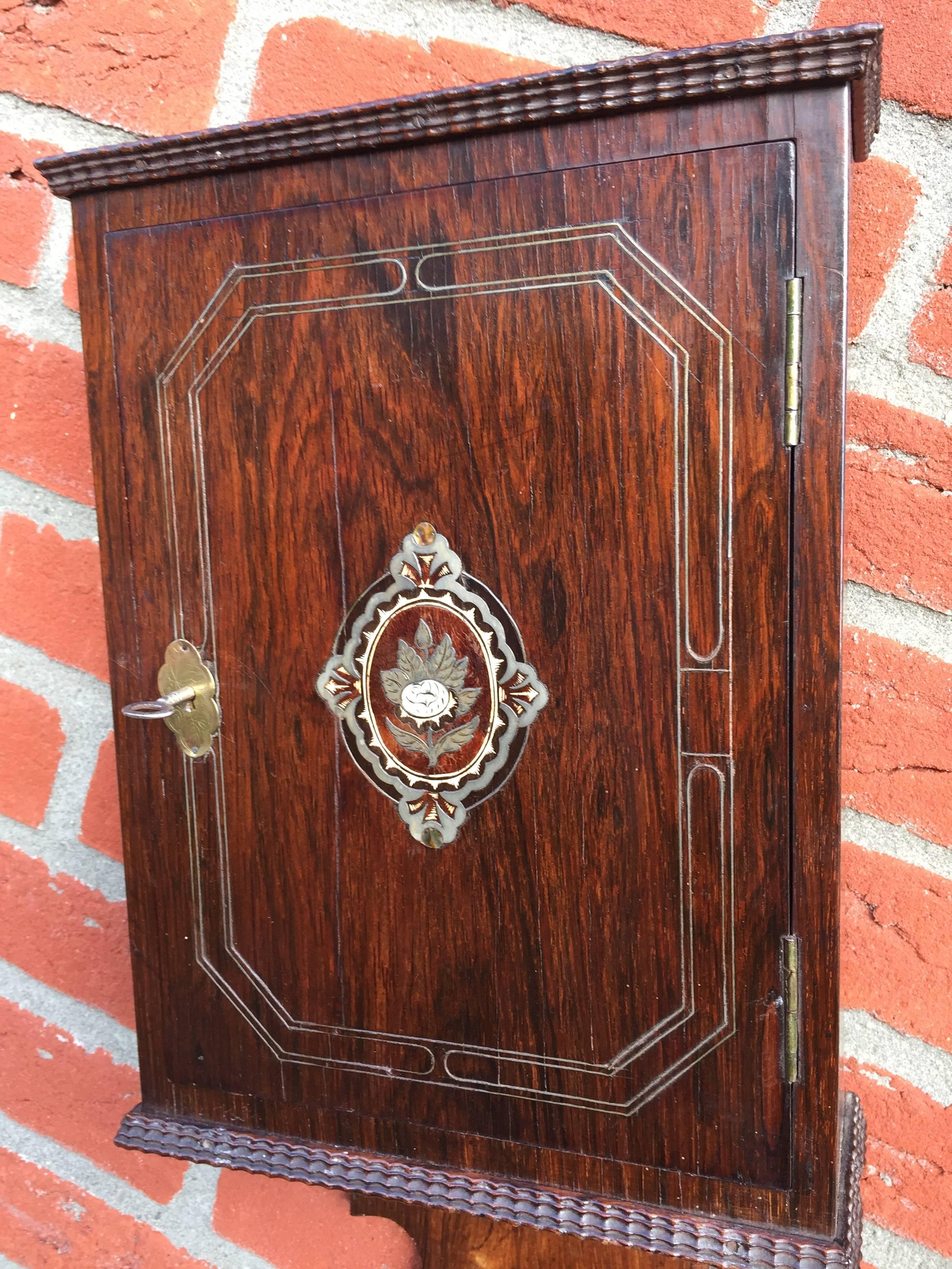 This antique key cabinet is in completely original condition.

Easy to mount on the wall you will have a rare and practical 'key organizer'. This beautifully veneered wall cabinet comes with an inlaid medaillion in the center of the door. The