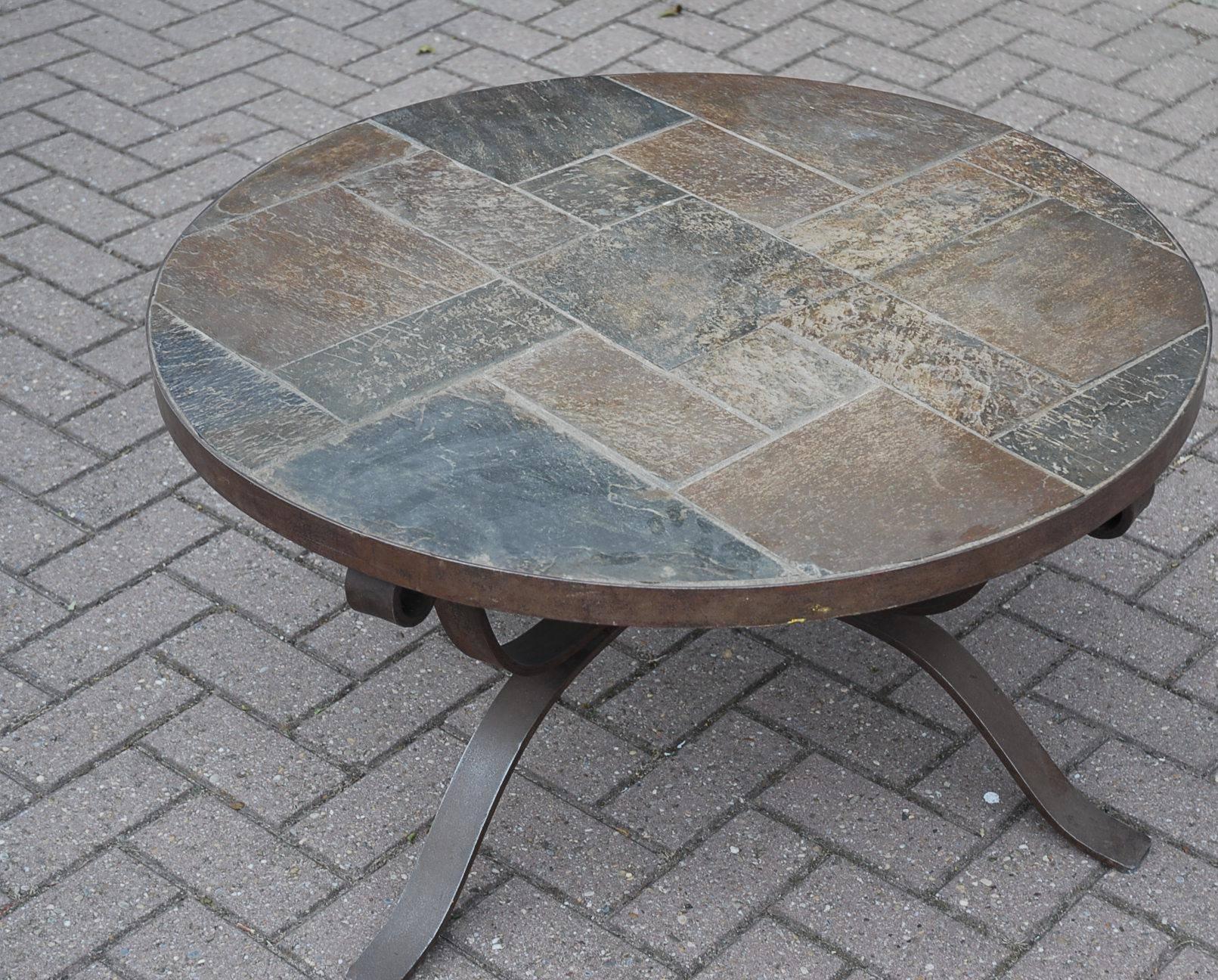 A sturdy and handmade coffee table from circa 1950.

This heavy and robust table comes with a wrought iron Art base and a round slate top. Undeniable quality craftsmanship that will last for centuries.

If you like this, coffee table as much as we