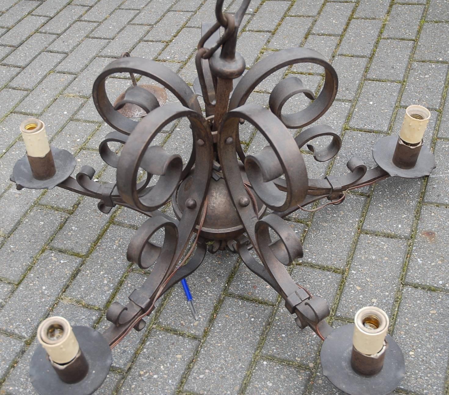 Heavy quality, handcrafted wrought iron chandelier.

This artistically designed and very well excecuted wrought iron chandelier is in excellent condition and it comes with dragon heads on all five arms. If you are looking for a statement piece