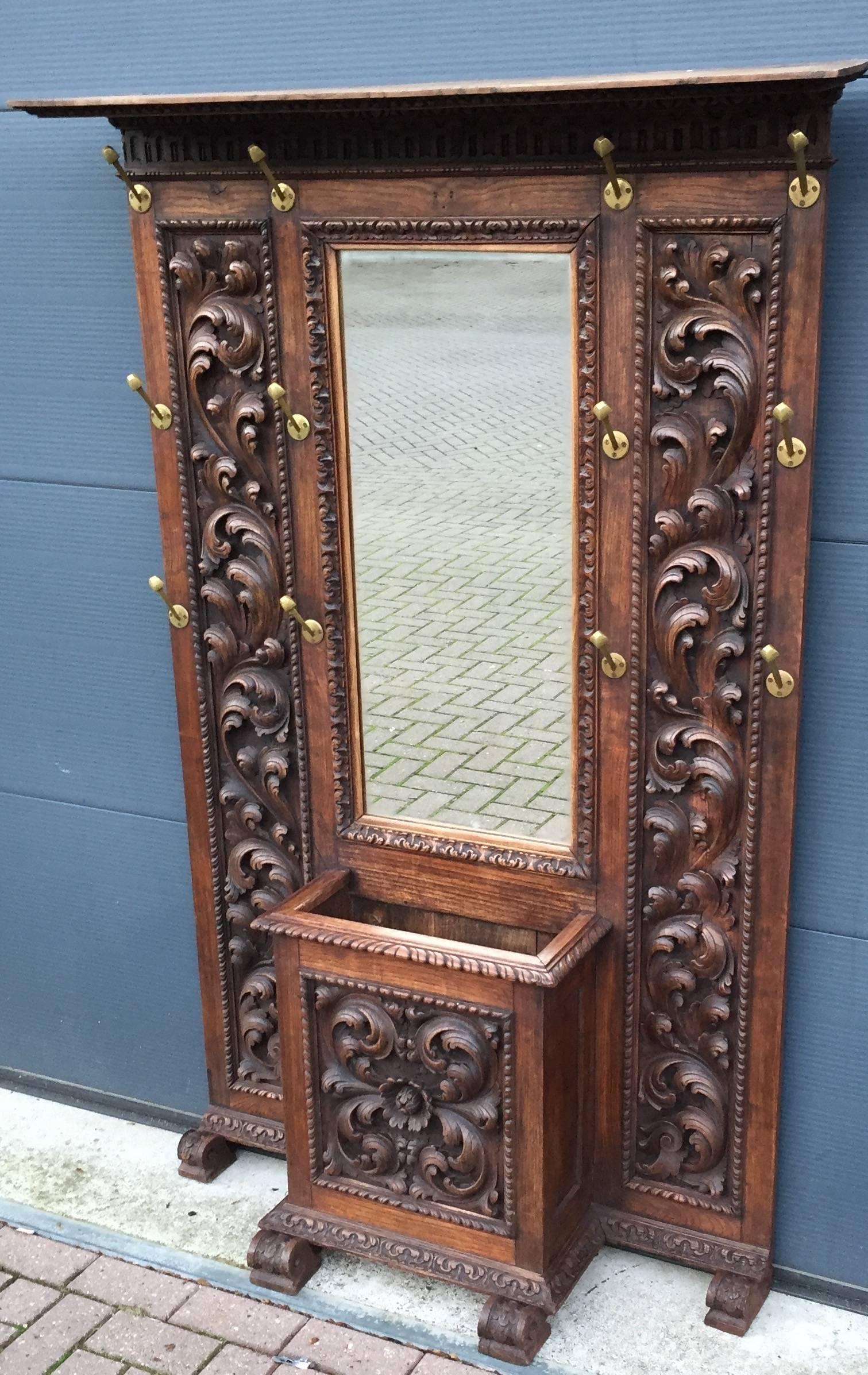 Multifunctional and majestic entrance furniture.

This stunning carved oak piece of wall furniture is multifunctional, because it is perfect for hanging up many coats and there also is a built-in umbrella stand with a zinc bottom. Apart from that