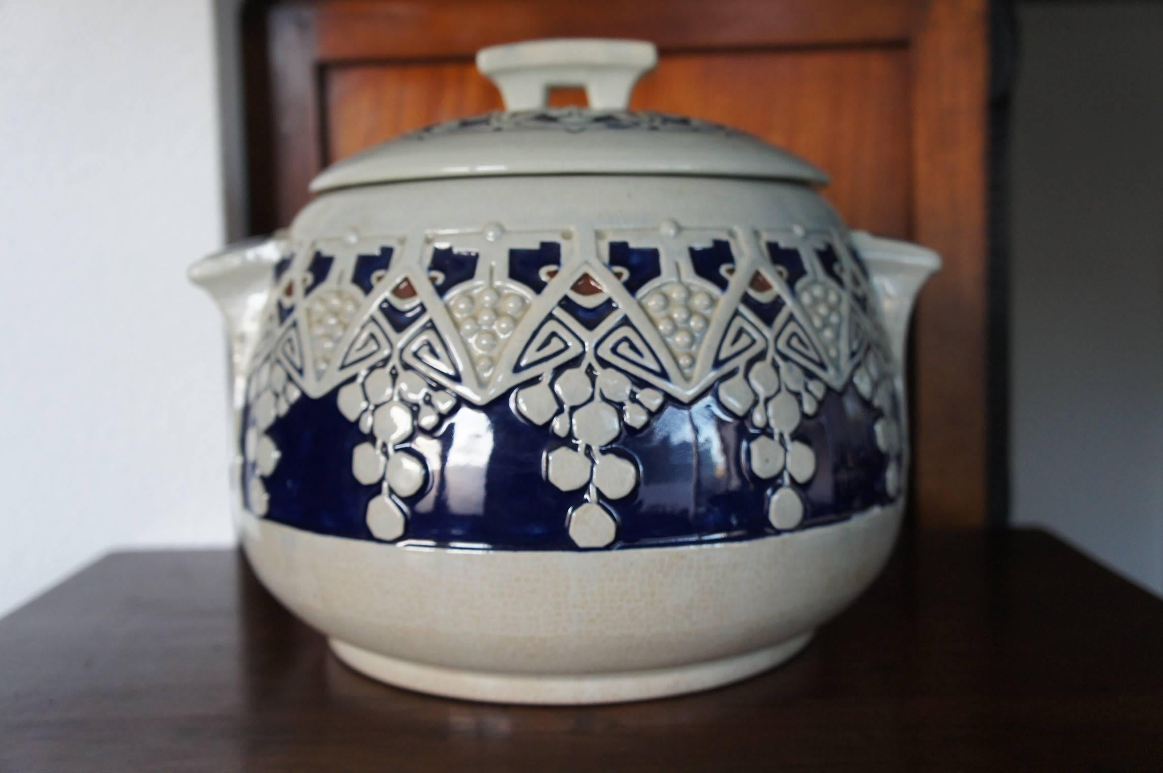 This handcrafted punch bowl is in excellent condition.

The Jugendstil motives on this glazed earthenware punchbowl are stunning. The glazing is done in a similar technique as enamelling and the result with the deep blue color is beautiful. There is