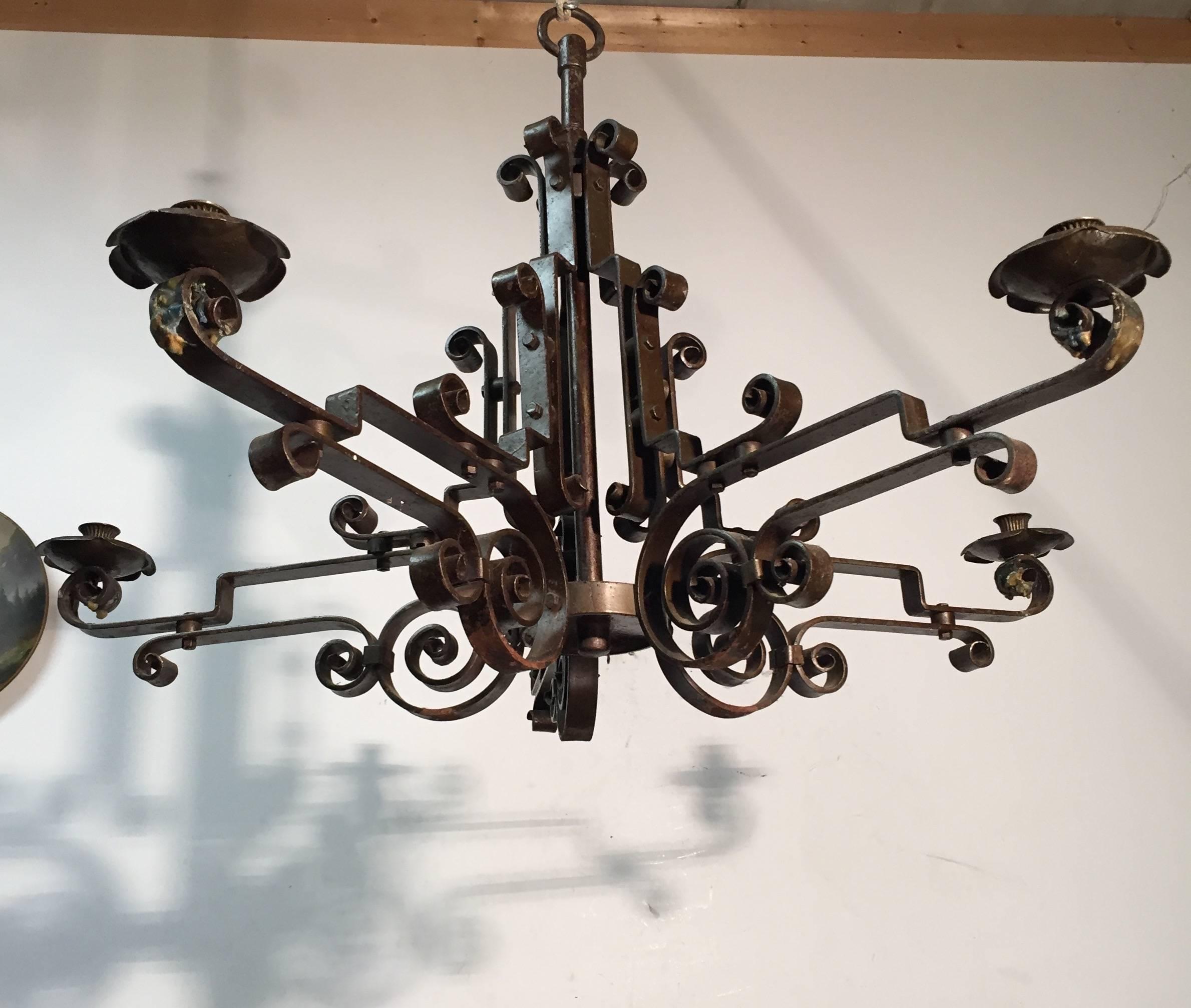 Large hand crafted chandelier for candles. . .can also be made electrical.

This beautifully designed 5 arm wrought iron pendant from circa 1940 is in good condition. The symmetrical and scrolled arms are very stylish in shape and a craftsman has