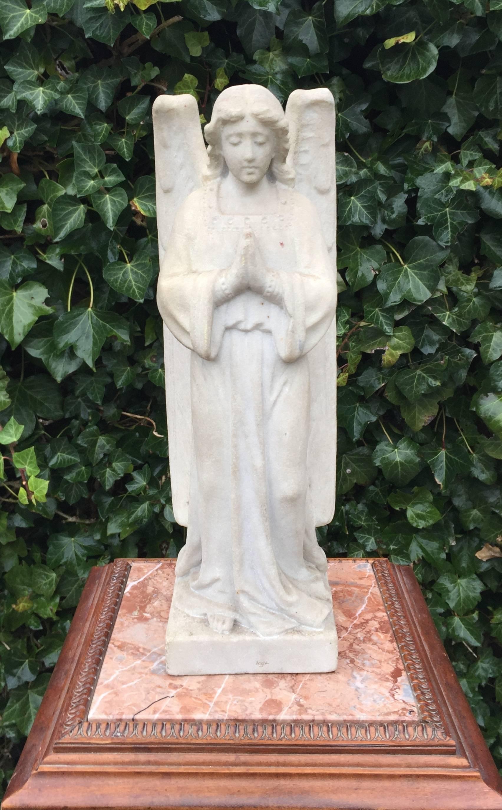 Antique solid marble standing angel in prayer.

This rare angel is entirely hand-carved out of marble. The arched wings, her beautifully draped cloth and her lovely, serene face are some of the elegant features that make this sculpture a joy to