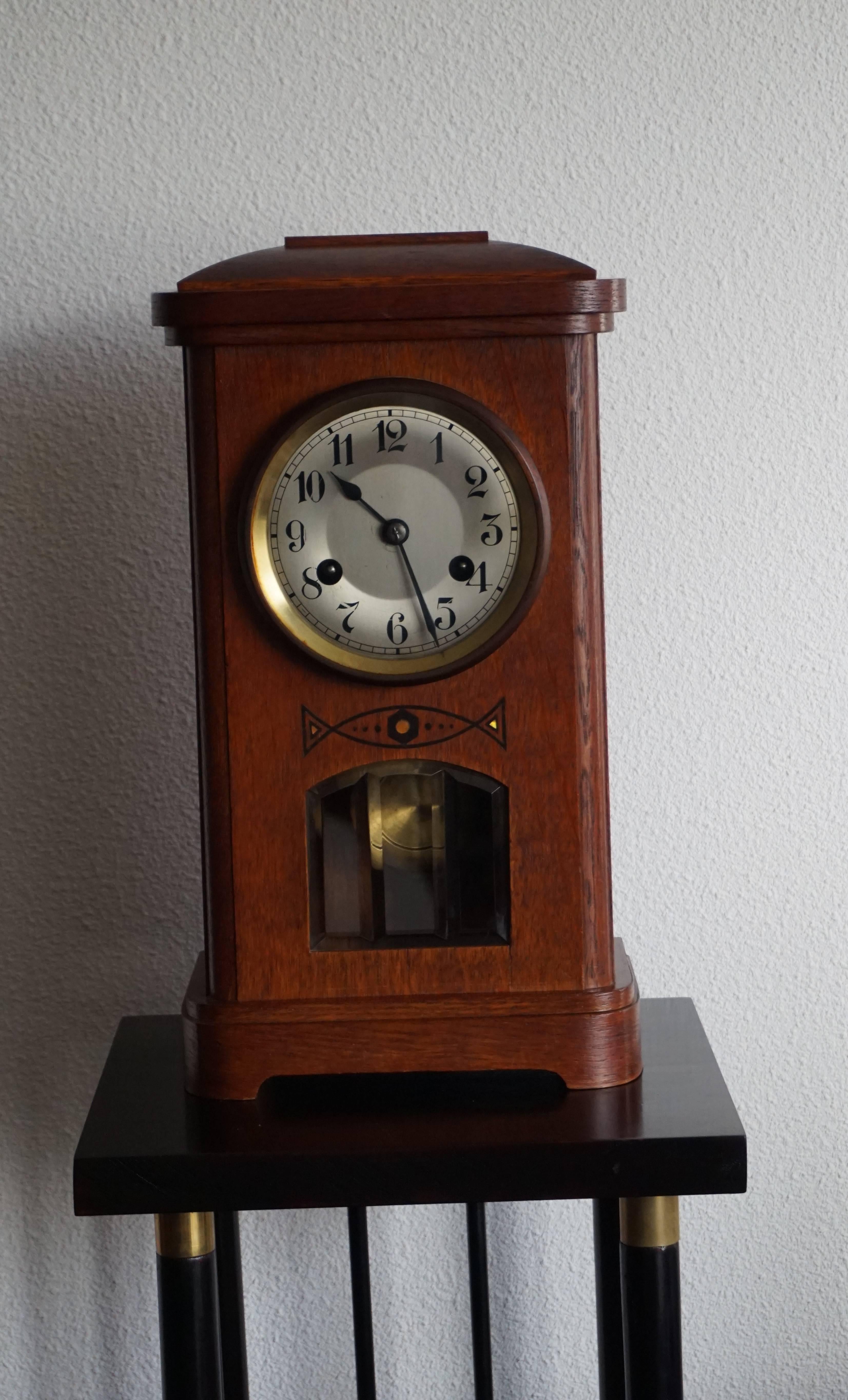 Beautiful Art Deco clock in good working order.

This stunning Art Deco clock has a beautiful patina, a clean and clear dial face with glass window/door in front, geometrical inlay of ebony and mother-of-pearl and a see through, beveled glass window
