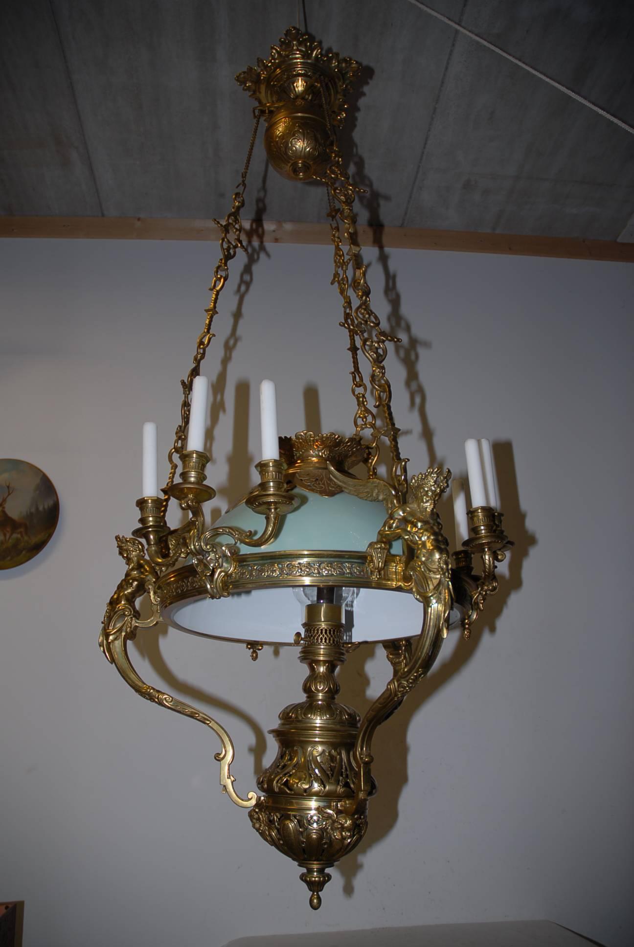 Unique bronze Zeus figures oil and candle ceiling light.

This large, heavy and finely detailed hanging oil lamp is probably unique. This stunning example comes with the original, green color shade. As you can see it is in the best possible