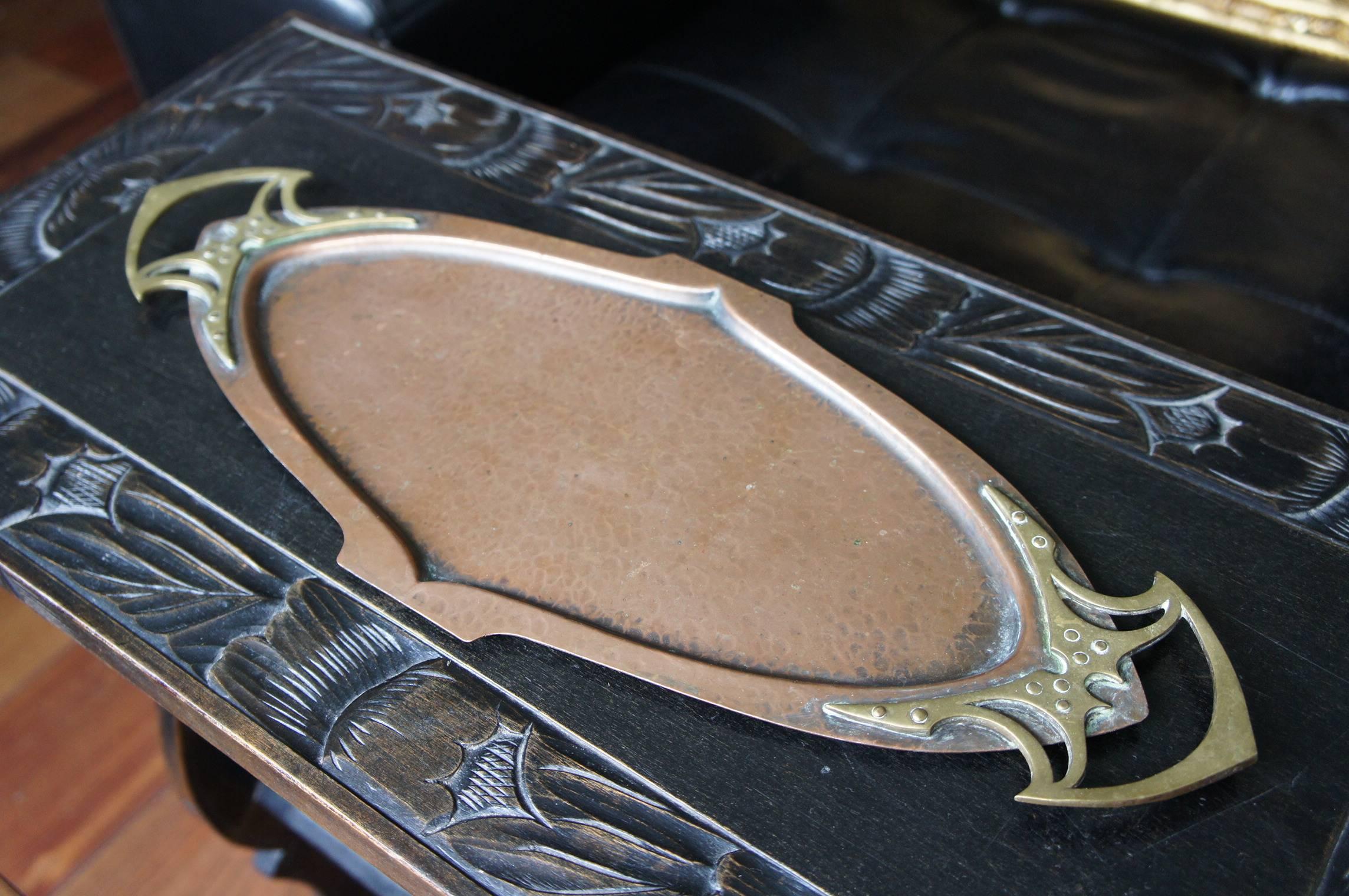 This antique Jugendstil tray is in excellent condition. 

The bottom of this tray has been entirely hand-hammered out of one piece of brass and patinated immediately afterward. The narrow and long design is accentuated by the impressive brass
