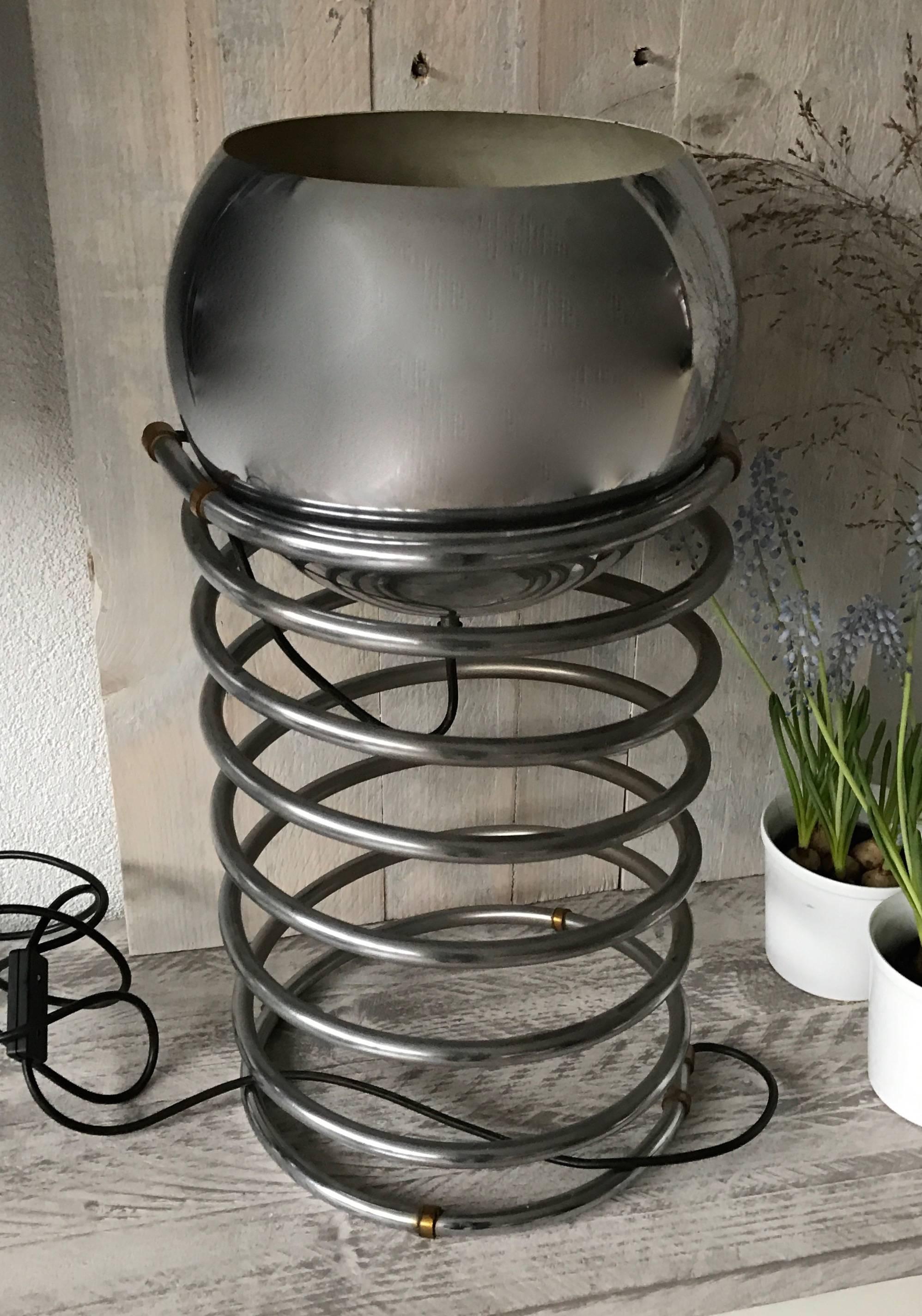 Vintage chrome metal table lamp with a barley twist.

This rare and practical spiral table lamp is in excellent condition. Because of the smart design it can be used in many ways with the light shining up, down or sideways. This vintage table or