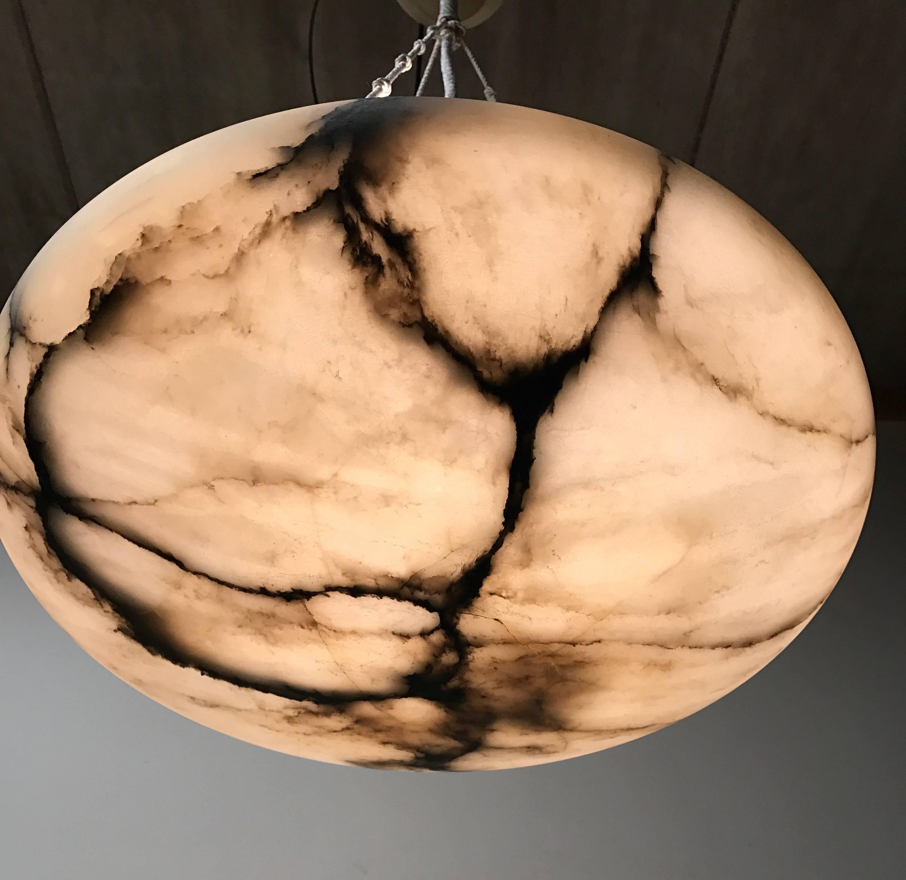 Top quality and great value for money.

This early 20th century, large alabaster pendant comes with new ropes and the original, matching alabaster ceiling cap. The shape, the color and the effect of the veins in this beautiful natural stone make