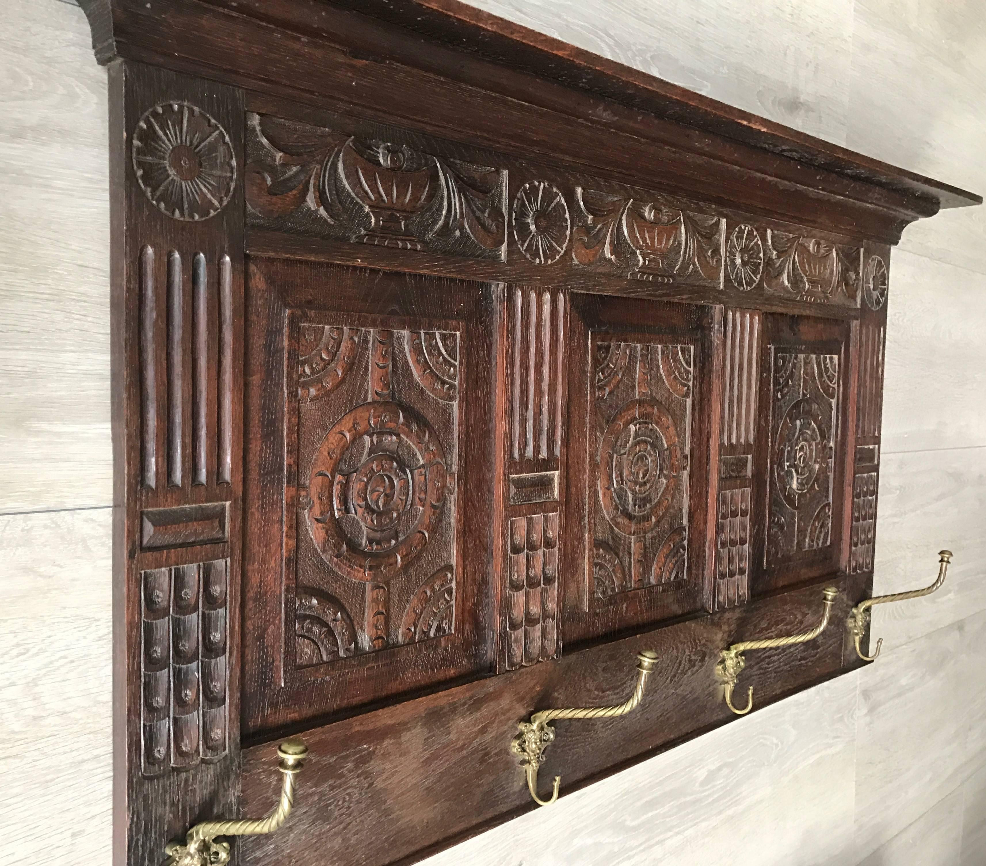 Beautiful handcrafted wall coat rack with original bronze hooks.

This 19th century coat-rack is a handcrafted work of art and it is in excellent condition, This good sized antique is entirely hand-carved out of solid oak and the beautiful,