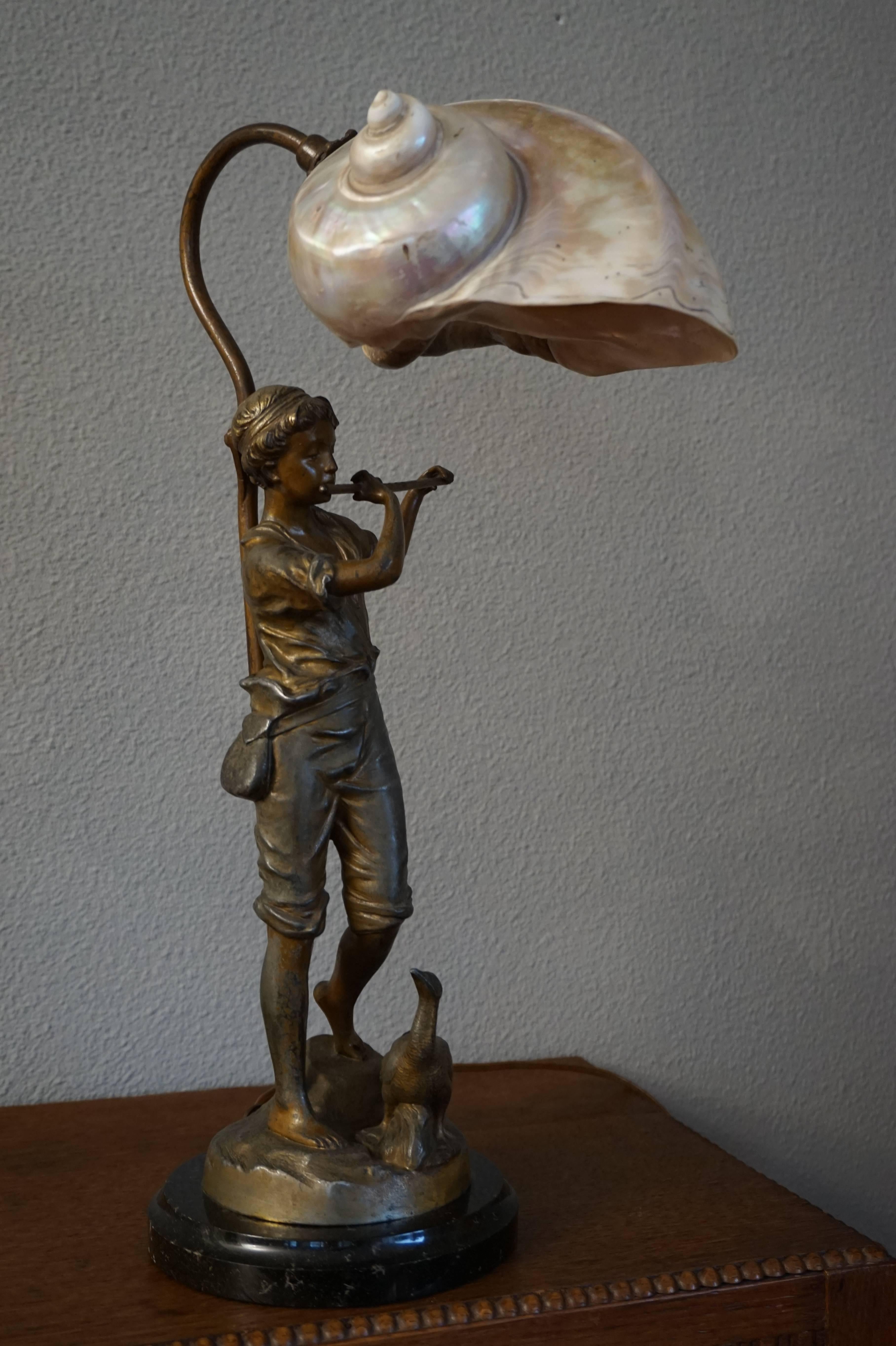 Rare and beautiful table lamp on a marble base.

This is the type of applied arts that really lifts your spirit. The fluit playing boy sculpture with it's realistic features and fine details radiates pure innocence. Even the bird feels at ease