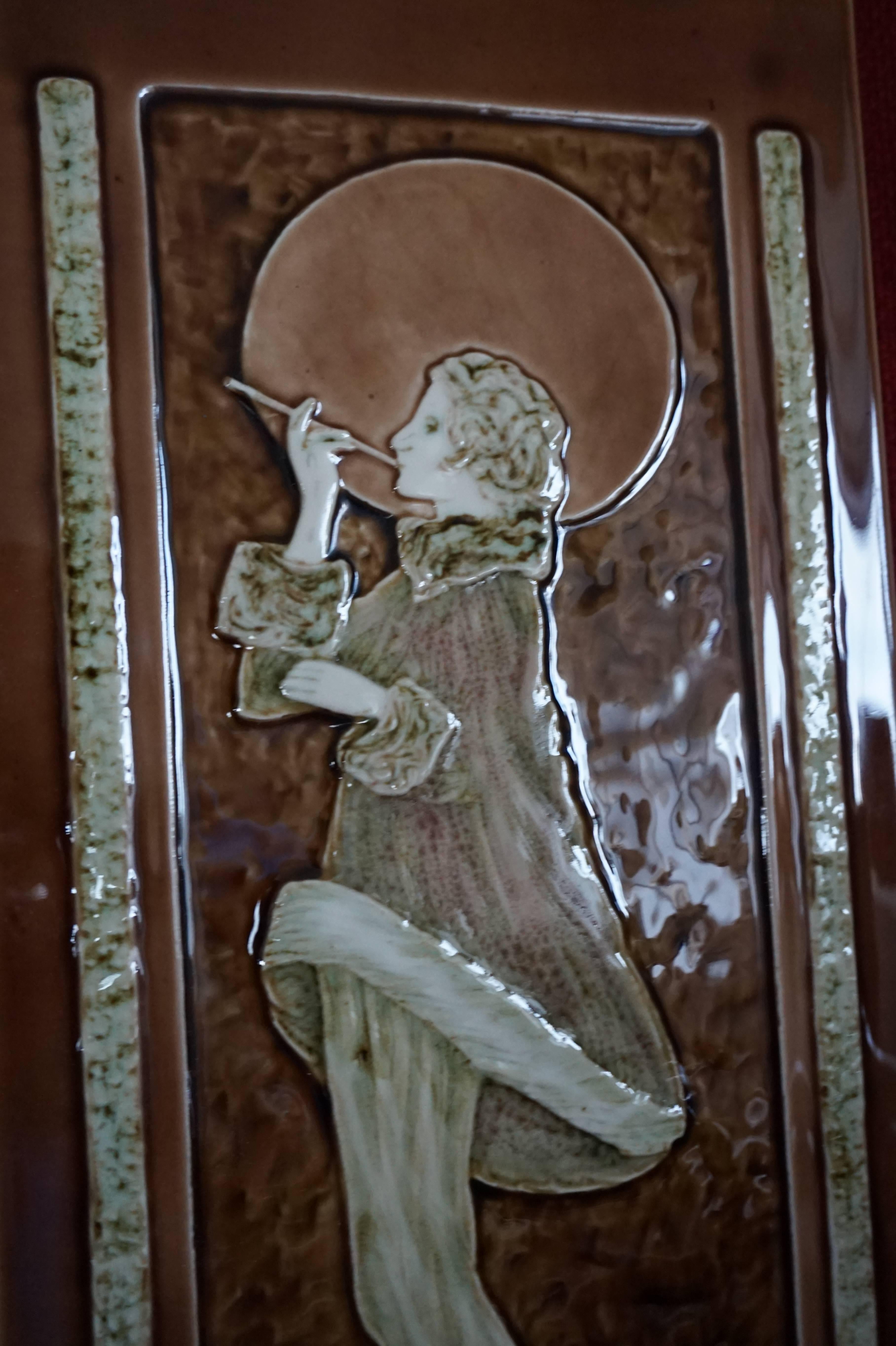 Rare and large tile with a stylish image of a beautifully dressed Art Deco lady.

This stunning tile may not be of the period, but the style is one hundred percent Art Deco and it is perfectly colored and Majolica glazed. This tile is thick and