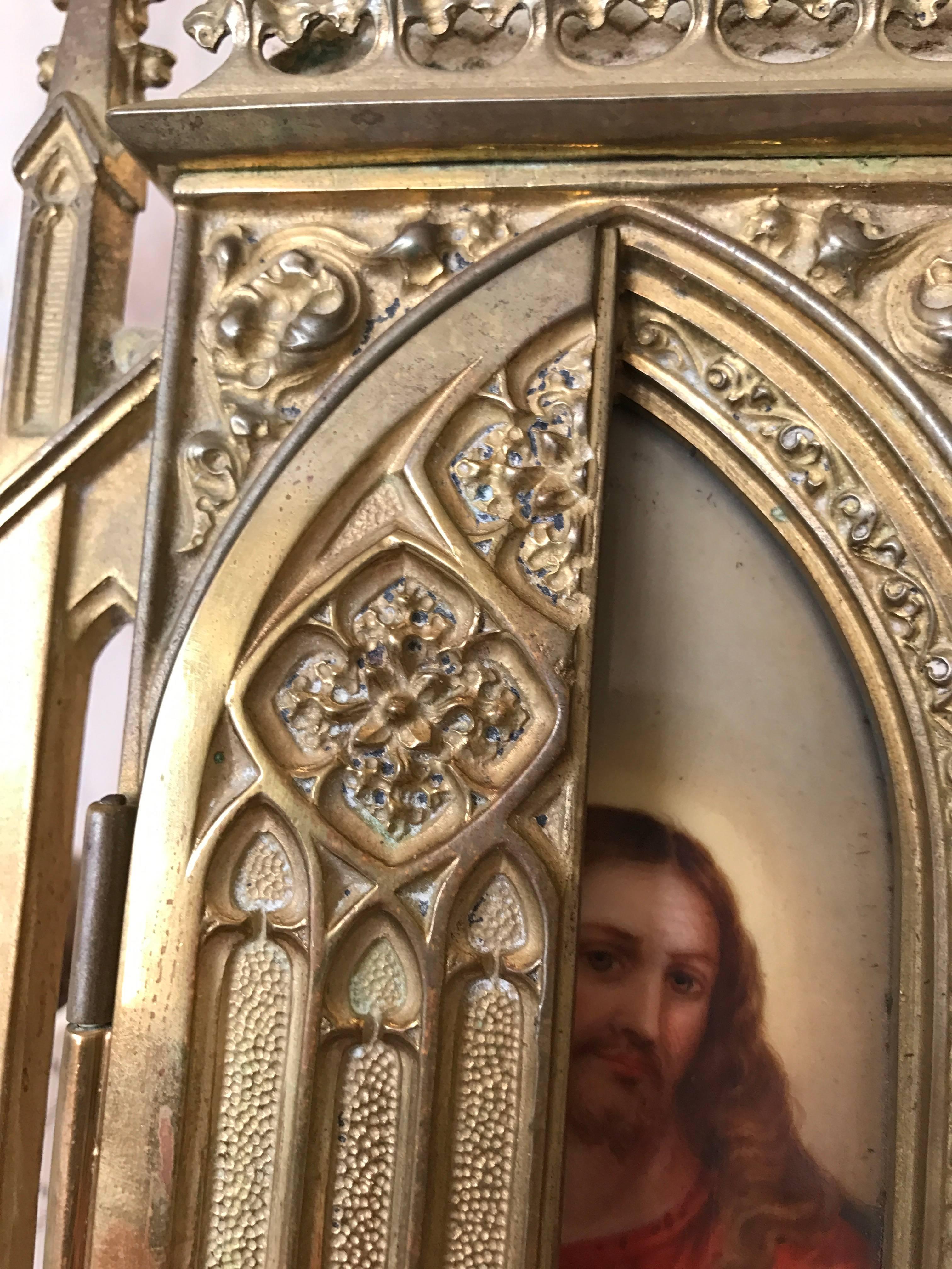 Marvellous antique picture frame with a hand-painted Christ on a porcelain plaque.

This antique, Gothic Revival picture frame with exquisite details is an absolute joy to behold. Behind the doors of this bronze chapel is a unique and great quality,