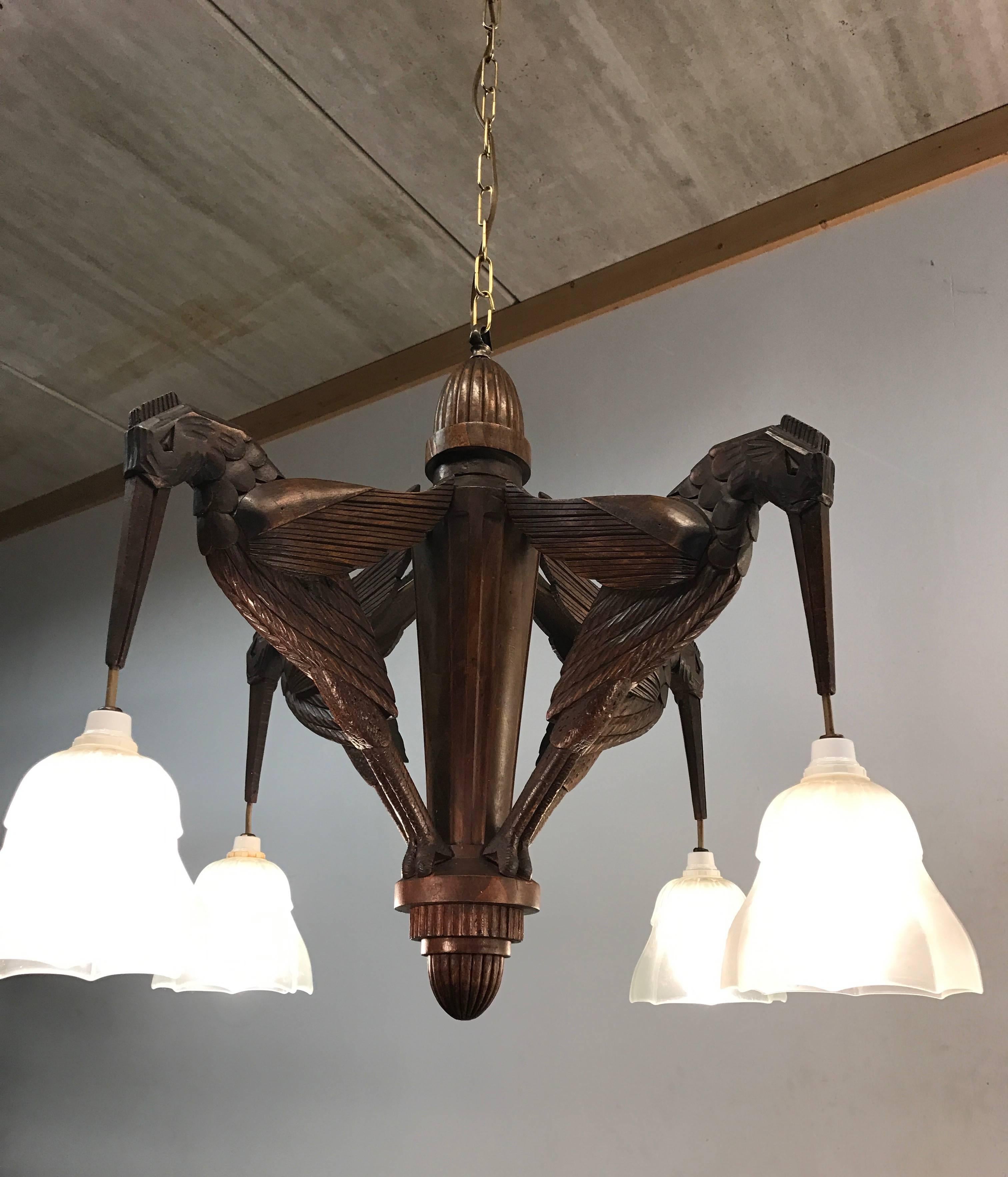 Unique, stylish and extremely decorative pendant.

If you are an applied arts enthousiast then this stunning Art Deco chandelier will really lift your spirit. This work of art from the early 1900s has four entirely hand-carved arms in the shape of
