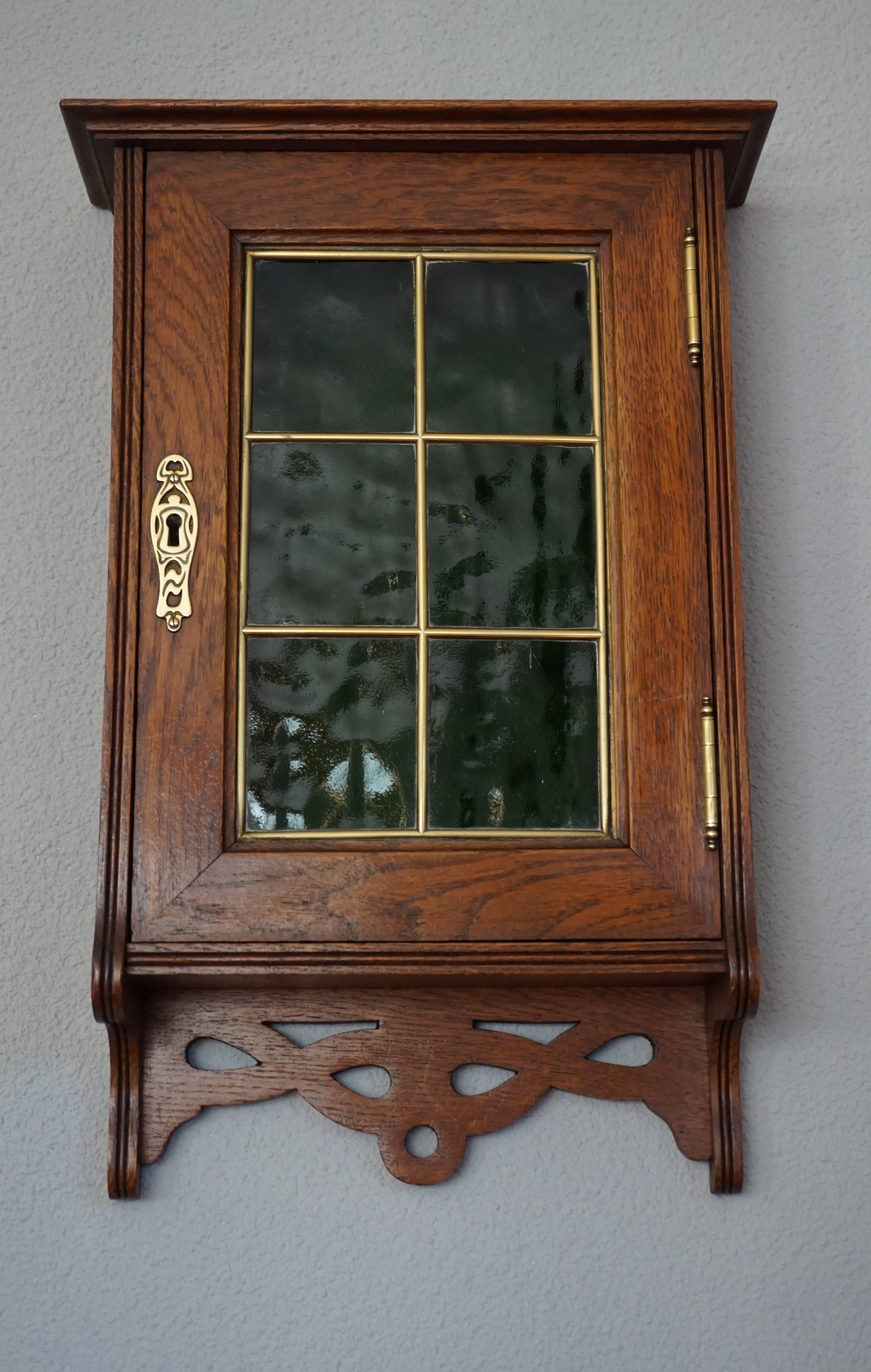 Beautiful and practical, antique wall cabinet with perfect working lock and key.

This handcrafted, early 1900's oak wall cabinet is a real beauty. The warm patina, the stylish shape, the mint condition and the antique cathedral glass are a match
