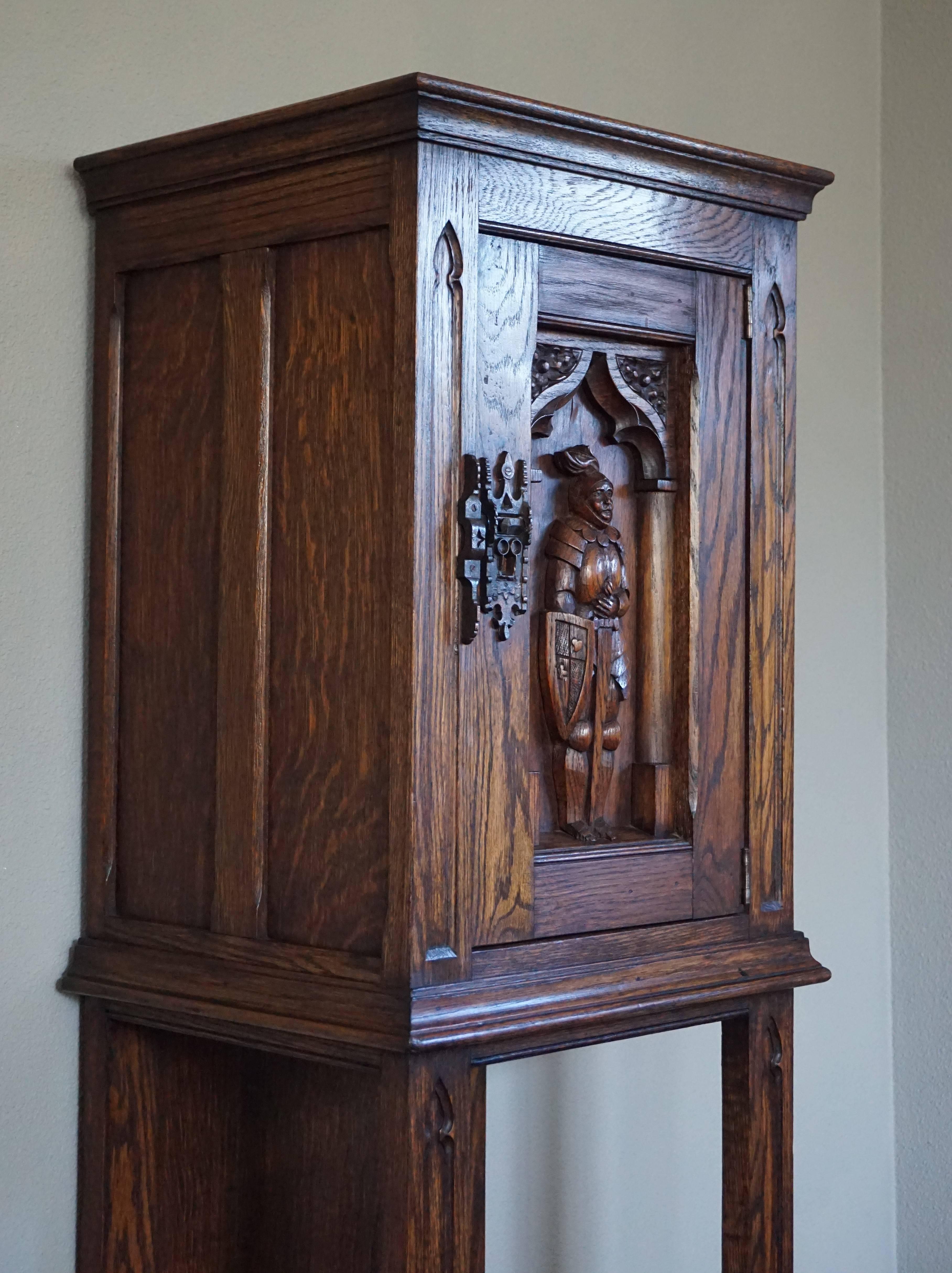Marvelous and practical Gothic Revival drinks cabinet.

This rare Dutch Gothic dry bar is in excellent condition and it is beautifully carved. The Knight in full armor looks like he is guarding the gate of a castle, because the door of this cabinet