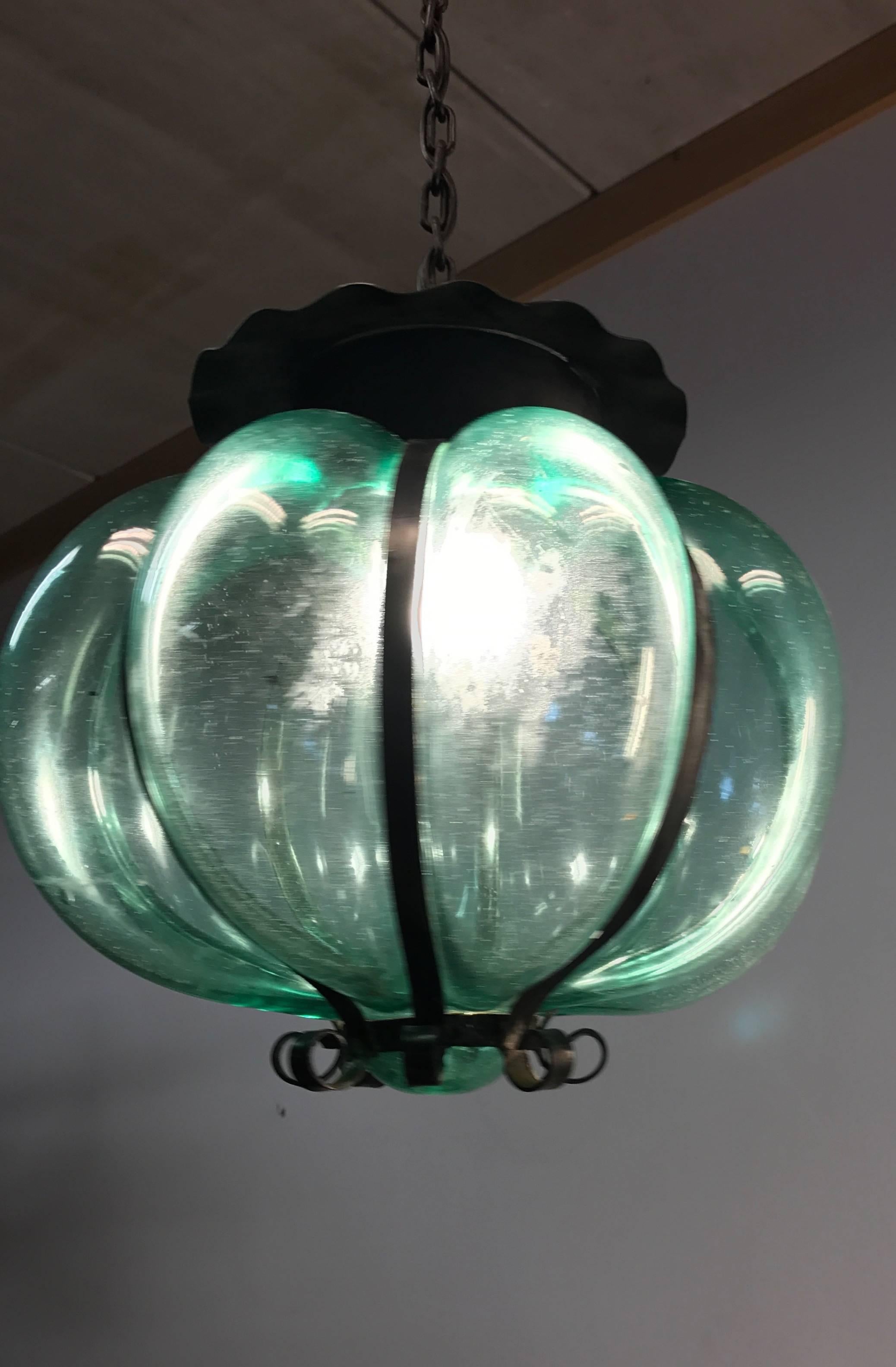 Beautiful blown green glass in metal frame, from circa 1950.

This timeless single light pendant is beautiful in shape and the mouth blown, green glass is in excellent condition. It comes with the original black chain and black metal canopy and the