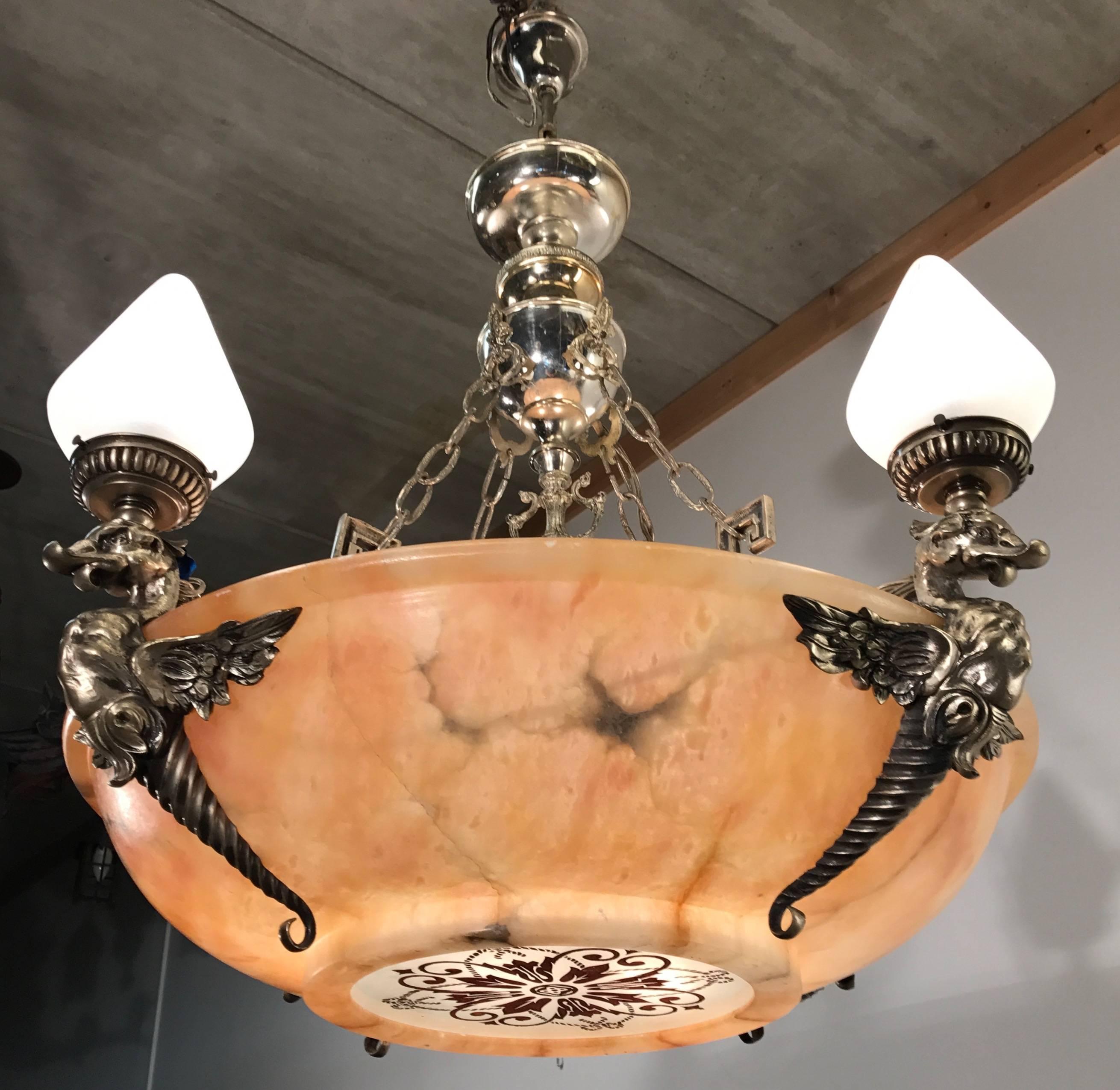 Amazing and impressive 1920s eight light pendant.

This sizeable and great quality, handcrafted pendant has the most beautiful shape and color combinations. The winged mythological animal sculptures on each 'corner' are silvered and a coating