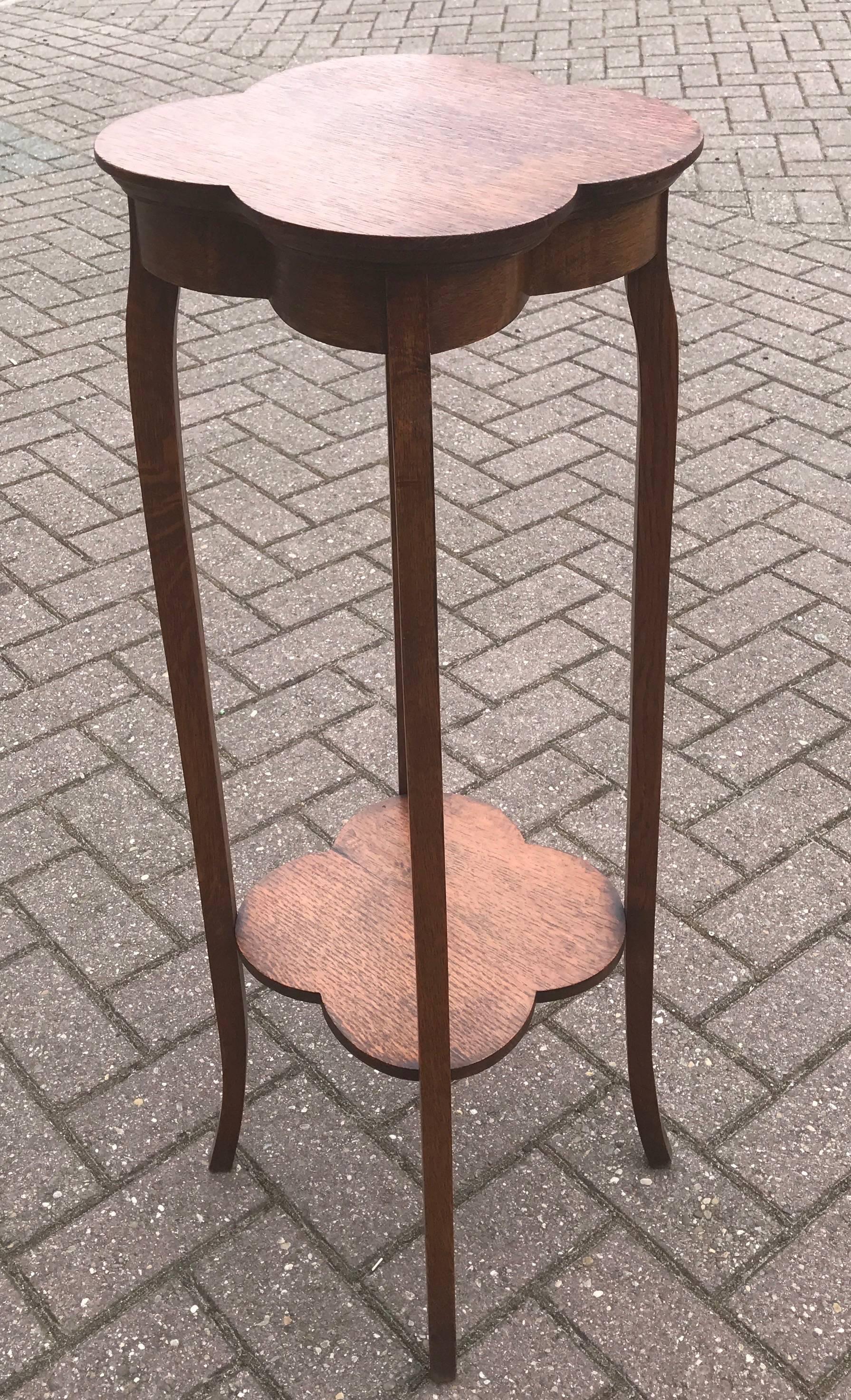 Stylish Arts and Crafts table with a stylized clover leaf top.

This elegantly shaped and all handcrafted plant stand from the early 1900s has a wonderful patina. This fine quality, oak table is as stable as the day it was made and it can be used