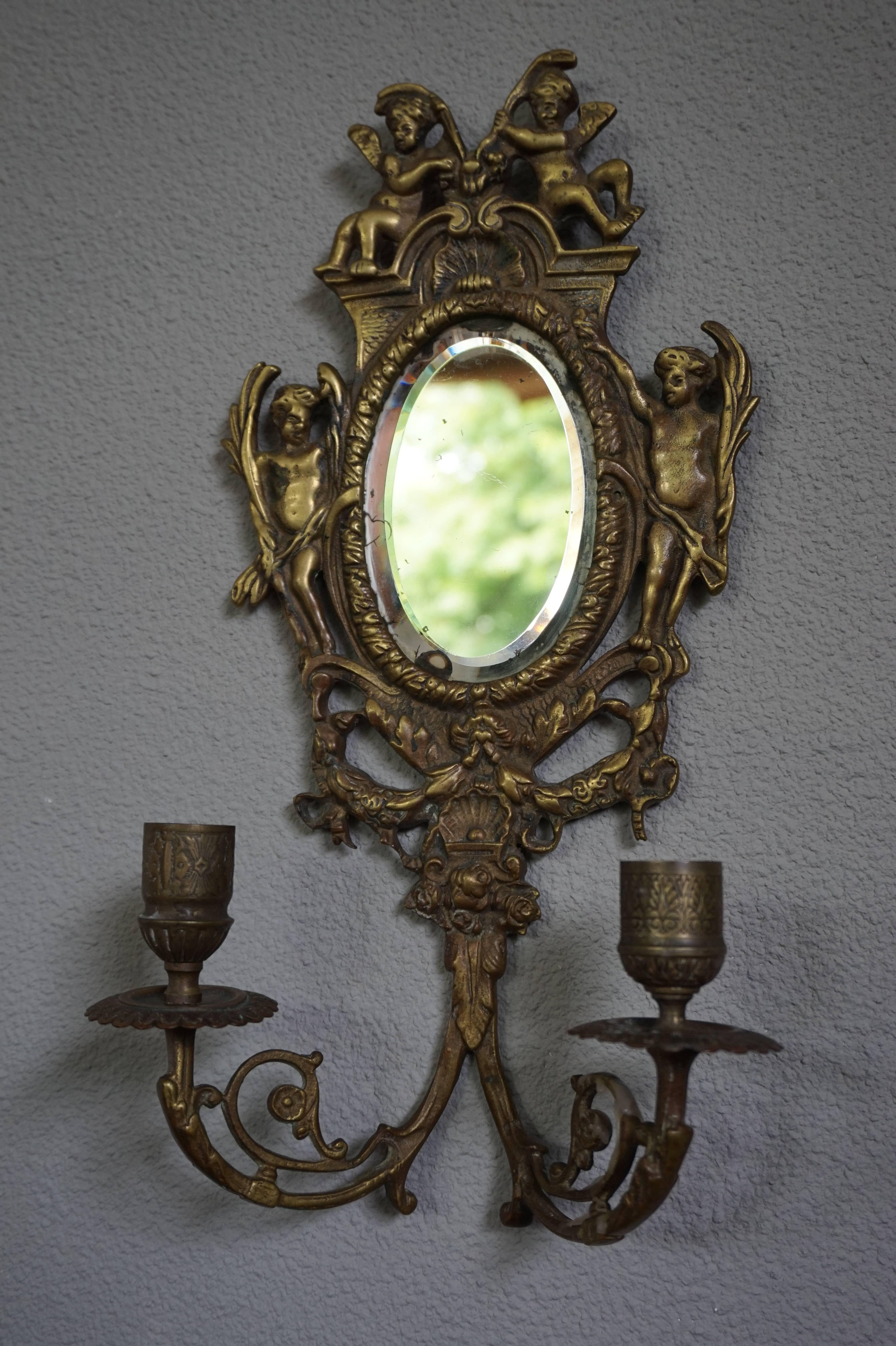 Practical size pair of Renaissance Revival sconces with putti and more.

This antique pair of sconces will look great above a side table, your bedside cabinets or in a hallway. This pair comes with the original, antique, small, beveled, oval