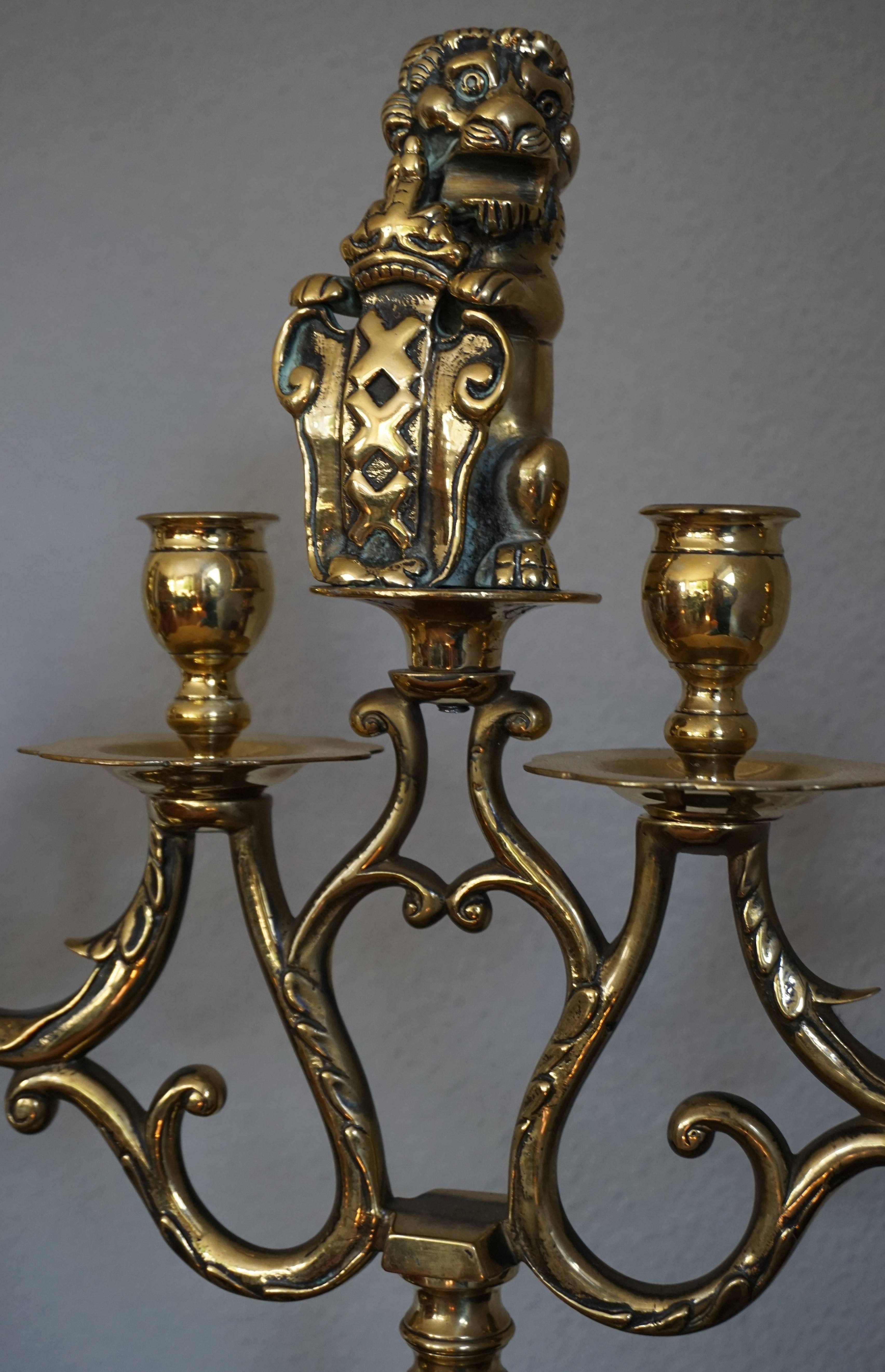Dutch Large Pair of Brass Candelabras with Lions Holding the Coat of Arms of Amsterdam For Sale