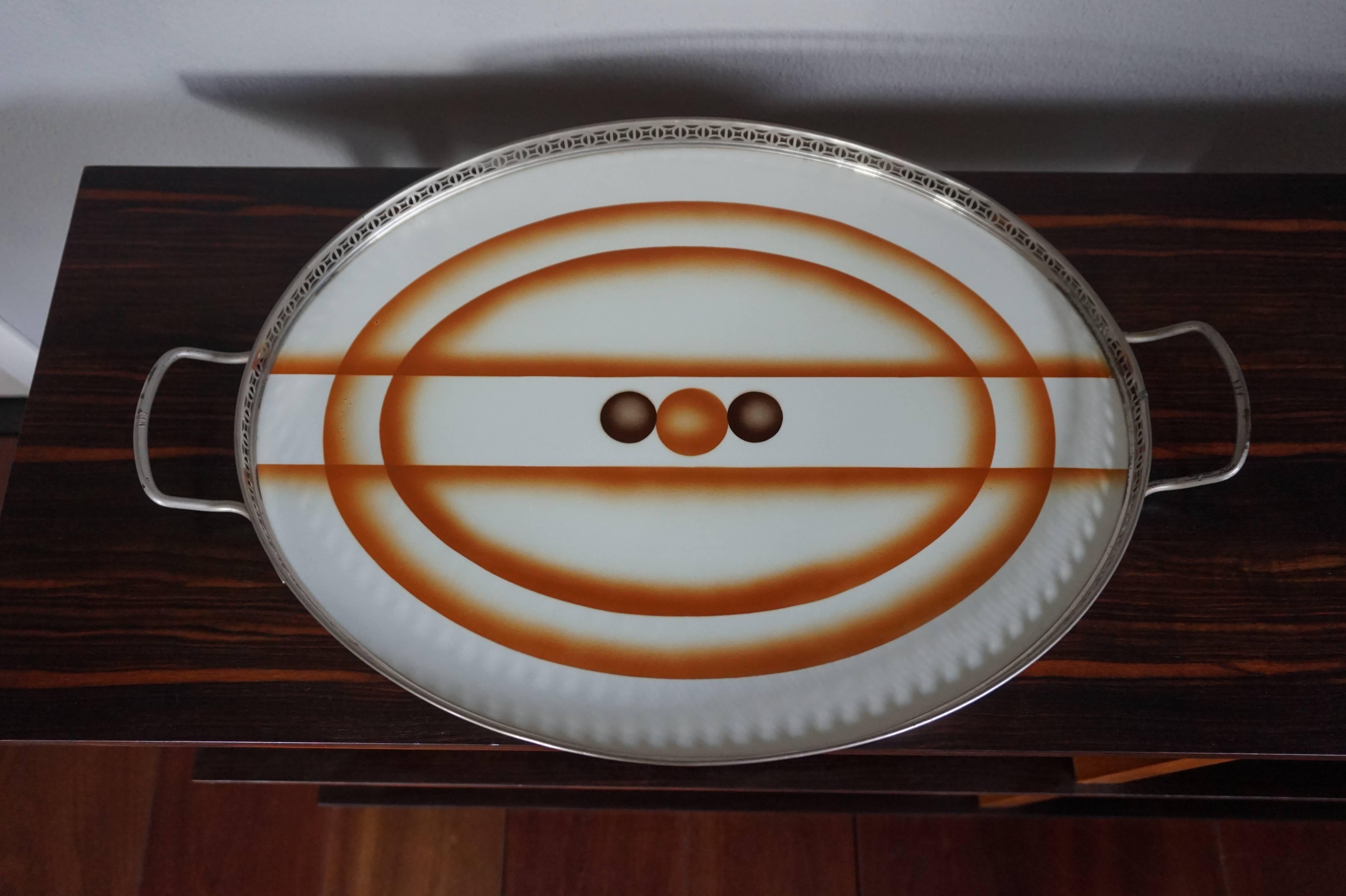 Stunning Art Deco serving tray from the 1920s.

We find it amazing that a serving tray, made of one large oval tile that is now a hundred years old, is in such a Fine condition. It can obviously be used to serve drinks or breakfast, but also on