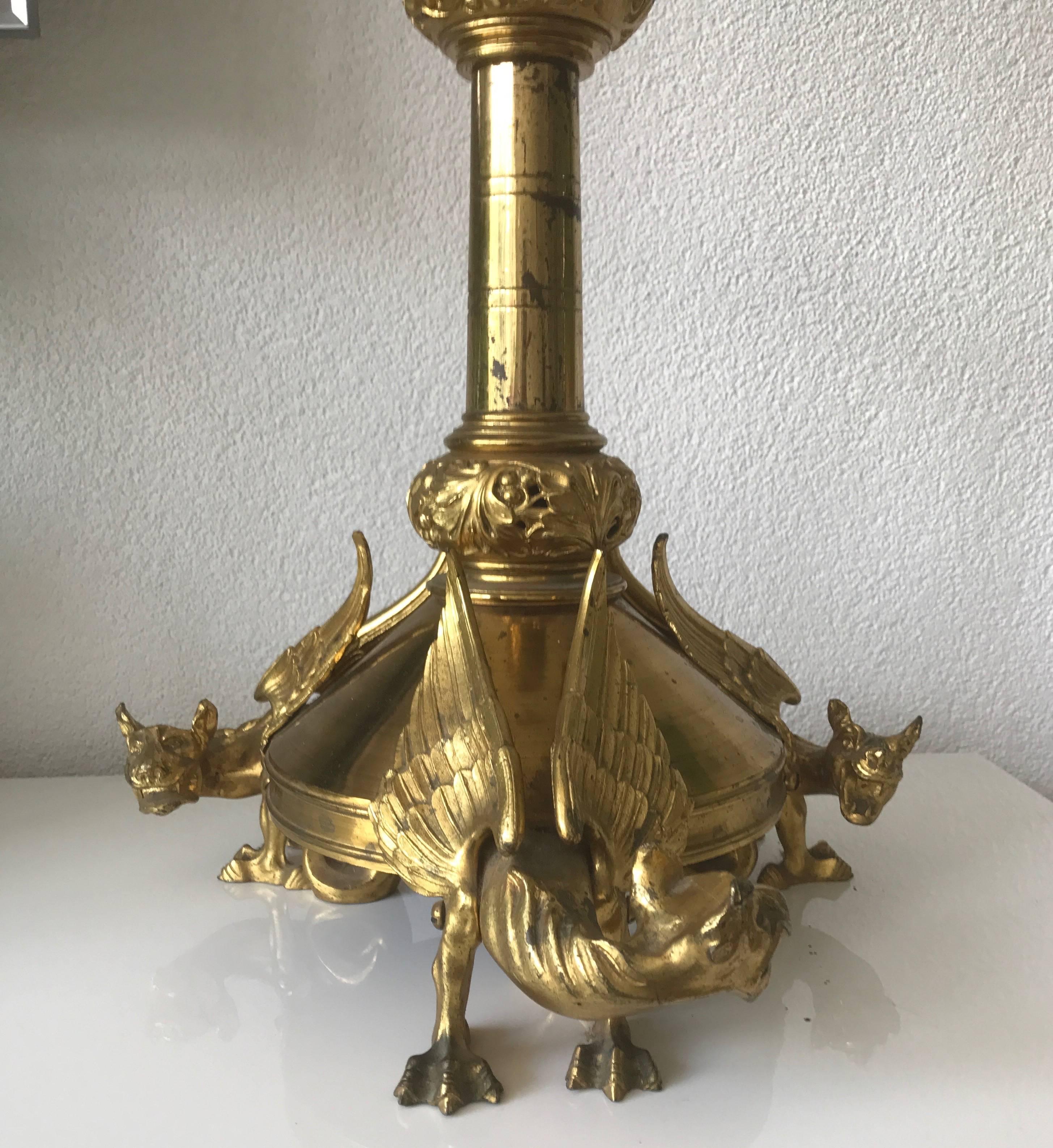 Stunning 19th century bronze and brass church altar candle holder.

This rare and decorative Gothic Style candlestick is both a joy to look at and practical to use. This altar piece has a tripod base of sculpted, gilt bronze chimeras. These winged,