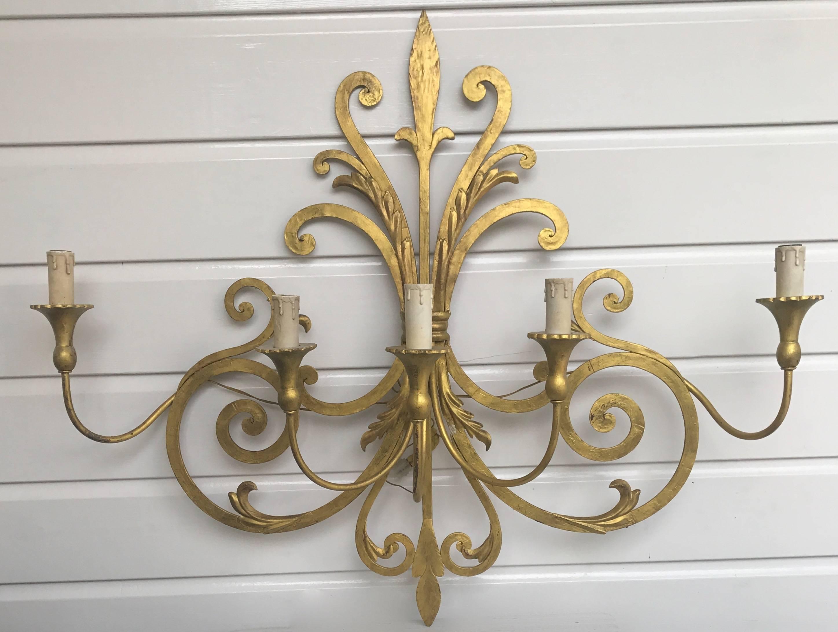 Large, handcrafted and elegant wall sconce.

This sizeable and handcrafted sconce comes with several gold painted scrolling motifs. This elegant shape is a joy to own and look at, both on and off. The thick scrolls in the back are made of