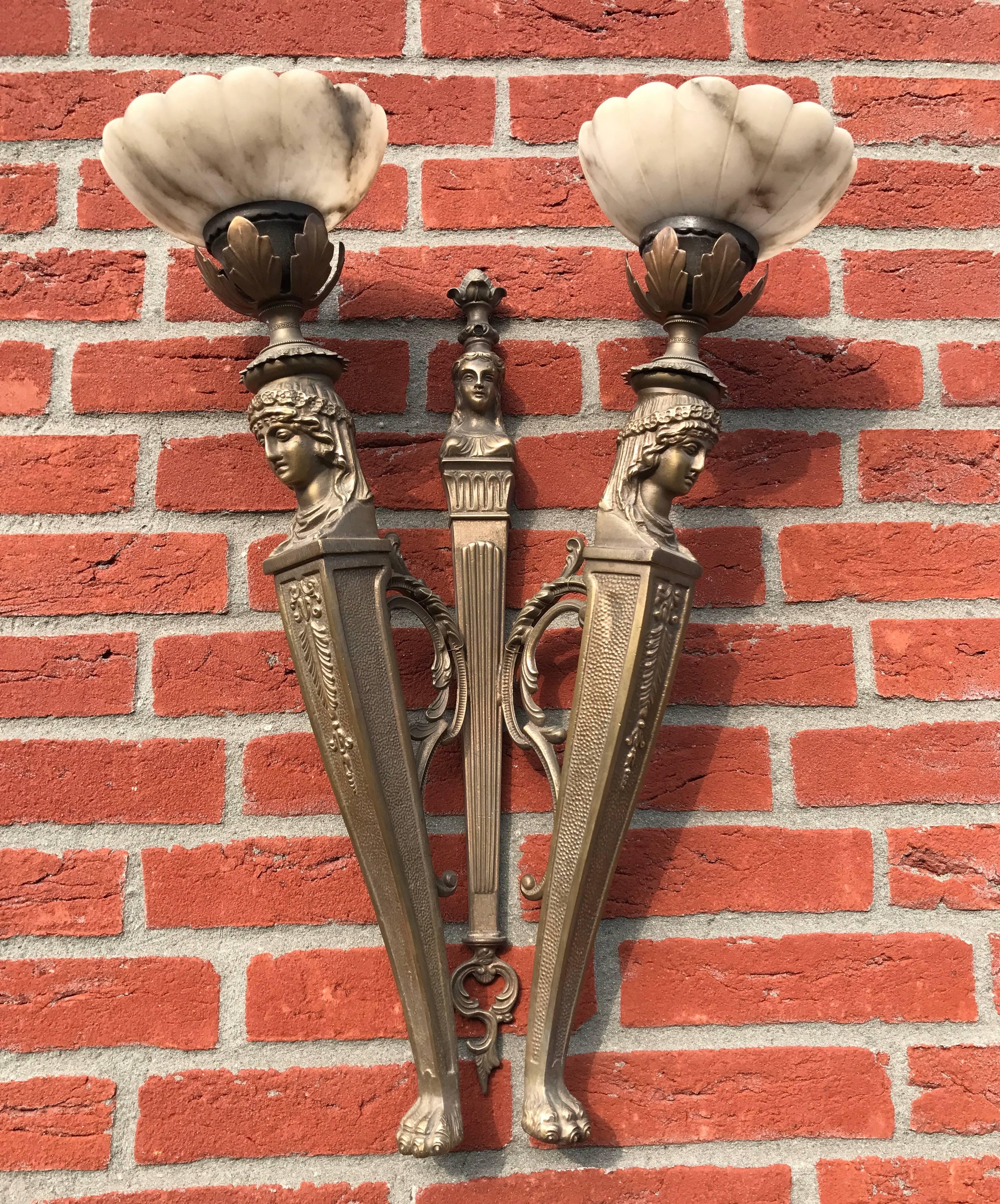 Early 20th century pair of highly decorative and sizeable wall sconces.

This large and beautiful pair of bronze wall lights is an absolute joy to look at, both on and off. The original and hand-crafted alabaster shades too are in excellent