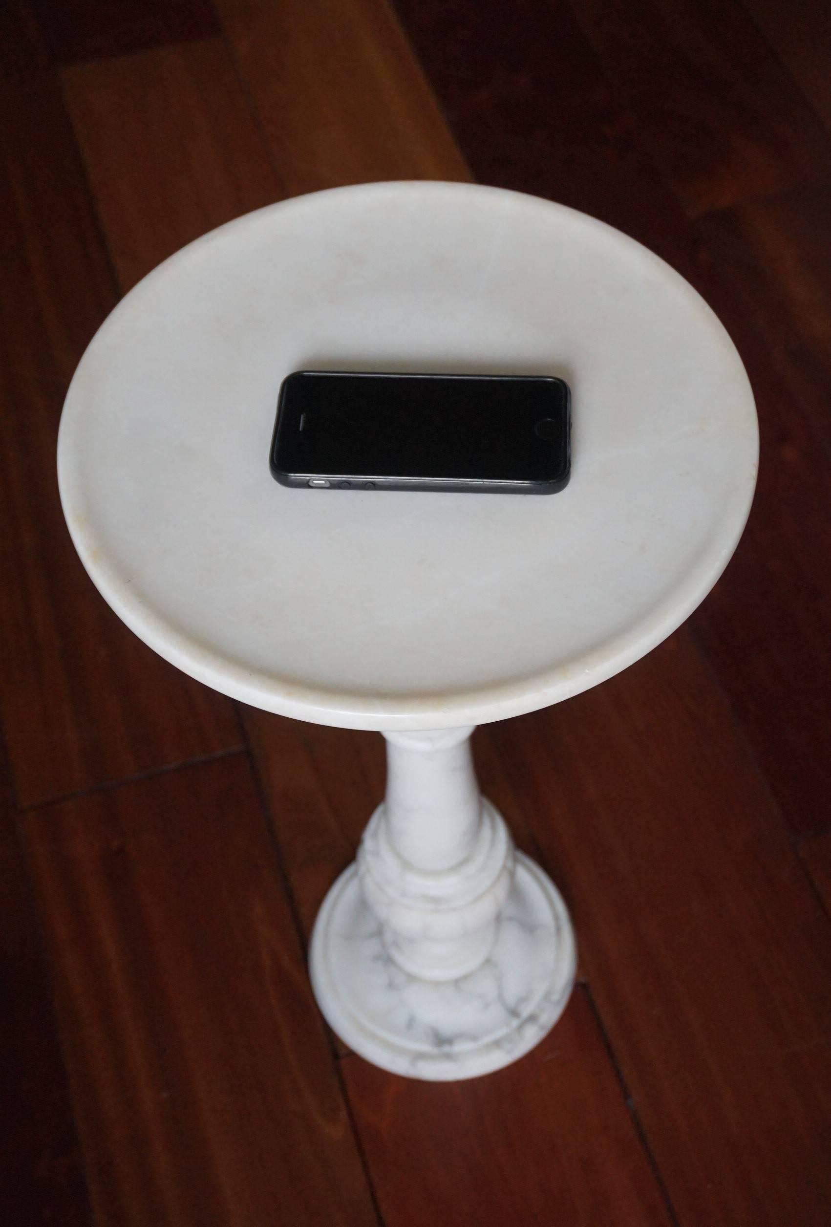 Beautiful and practical, handcrafted table.

This rare and beautifully shaped plant stand is entirely hand-crafted out of a beautiful white alabaster. This particular table looks a lot like caraca marble, but we think it is alabaster. This timeless