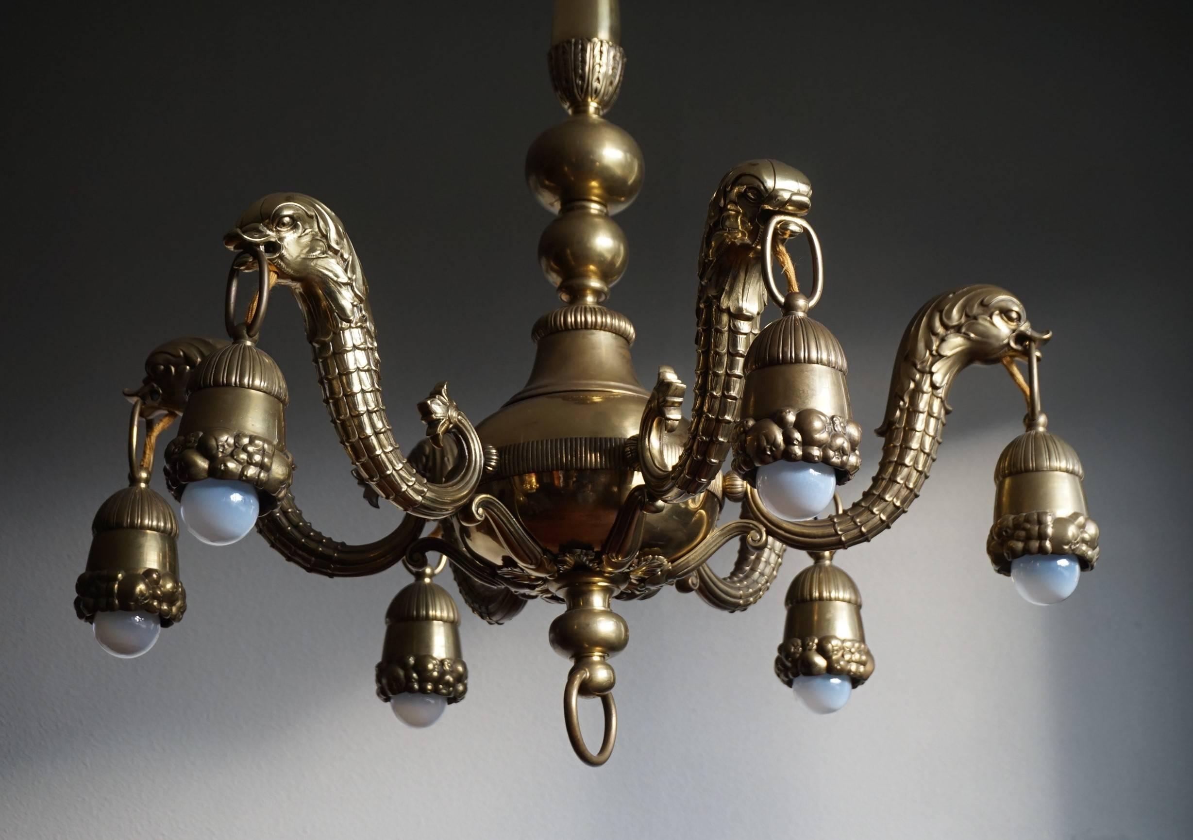 Unique and exceptional antique light fixture.

This handcrafted chandelier from the early 1900s is of exceptional quality and it is in amazing condition. All six arms are perfectly shaped like mythological and heraldic seahorse-like creatures. The