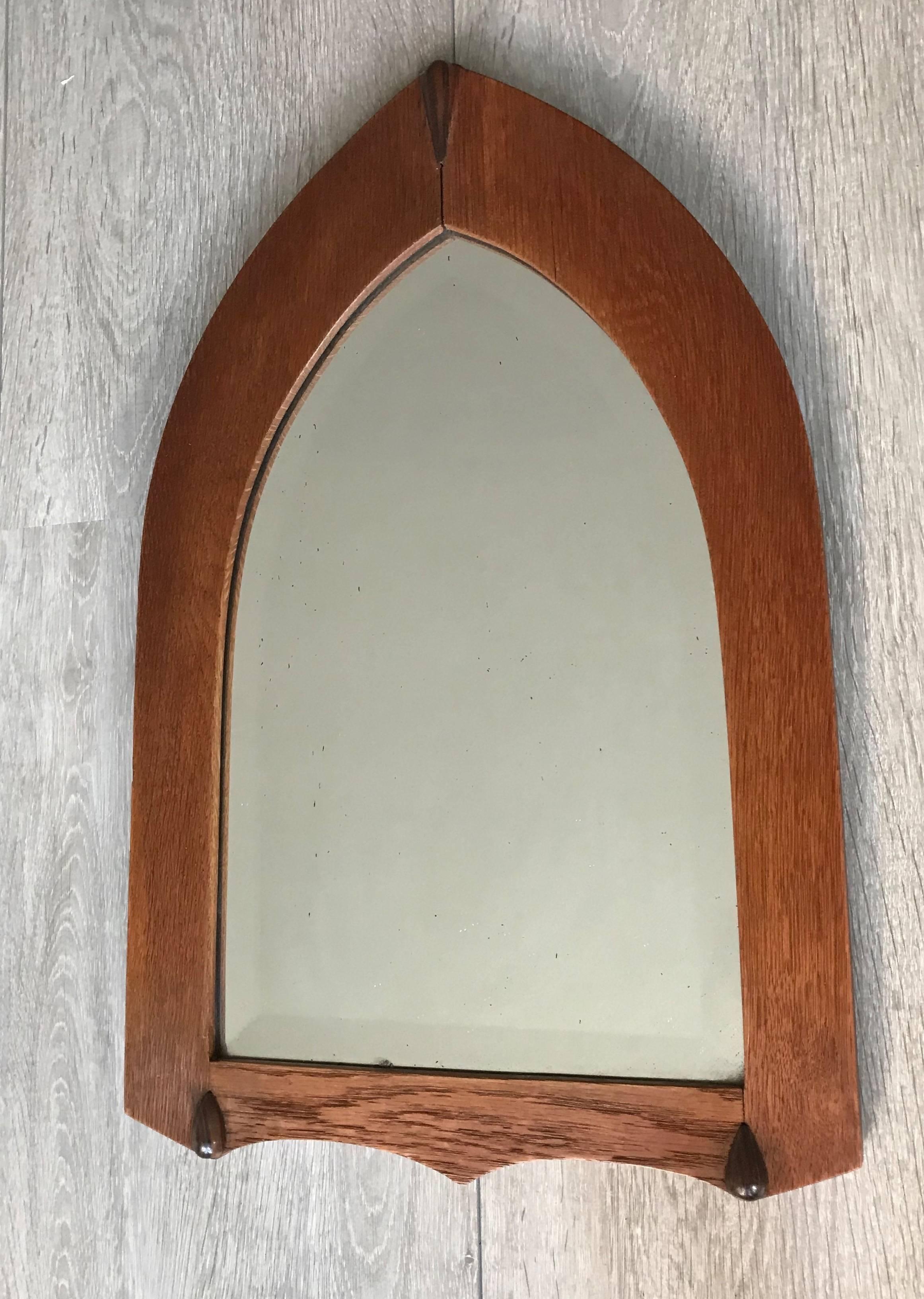Early 20th century, practical and stylish wall mirror.

This handcrafted and solid oak wall mirror is perfectly decorated with solid hardwood 'drops'. The shape of both the frame and bevelled mirror are perfectly accentuated by the grain in the