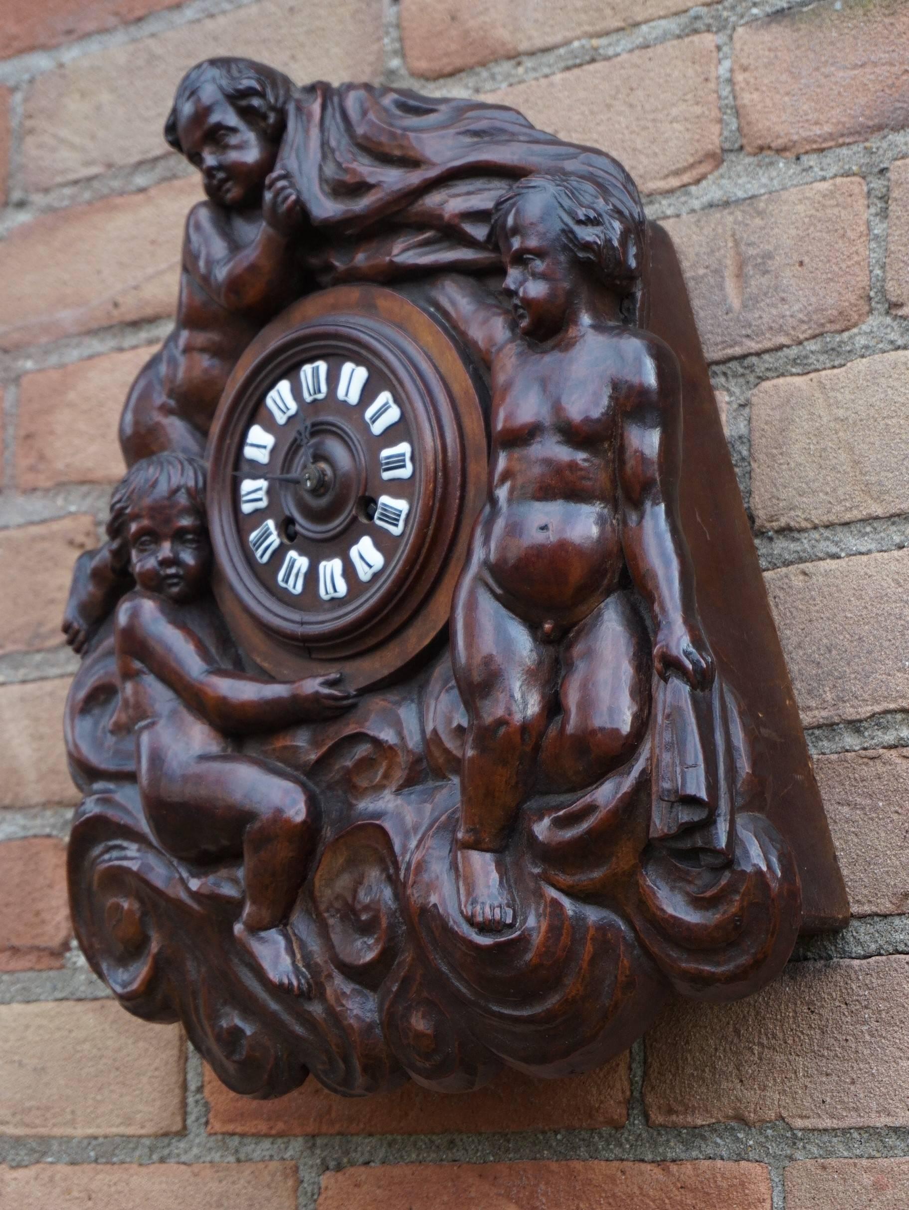 Stunning and unique walnut clock with carved angels in the clouds.

The magnificent front of this 19th century wall clock is entirely hand-carved out of one solid and thick piece of walnut. The wonderfully carved boy angels with one of them holding