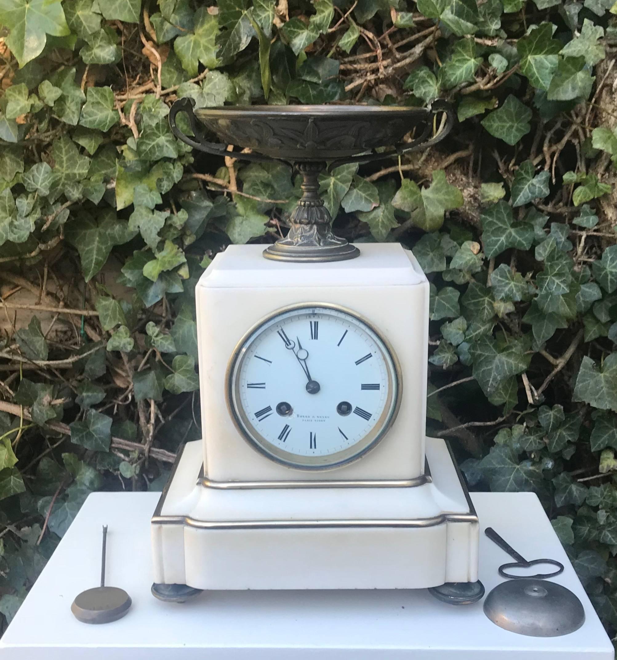 Practical size and beautiful shape, antique mantel clock.

This classical shape, white marble mantel clock comes with subtle details that make it very pleasing to the eye. The brass lining on the outside accentuate the shape and the bronze bowl on