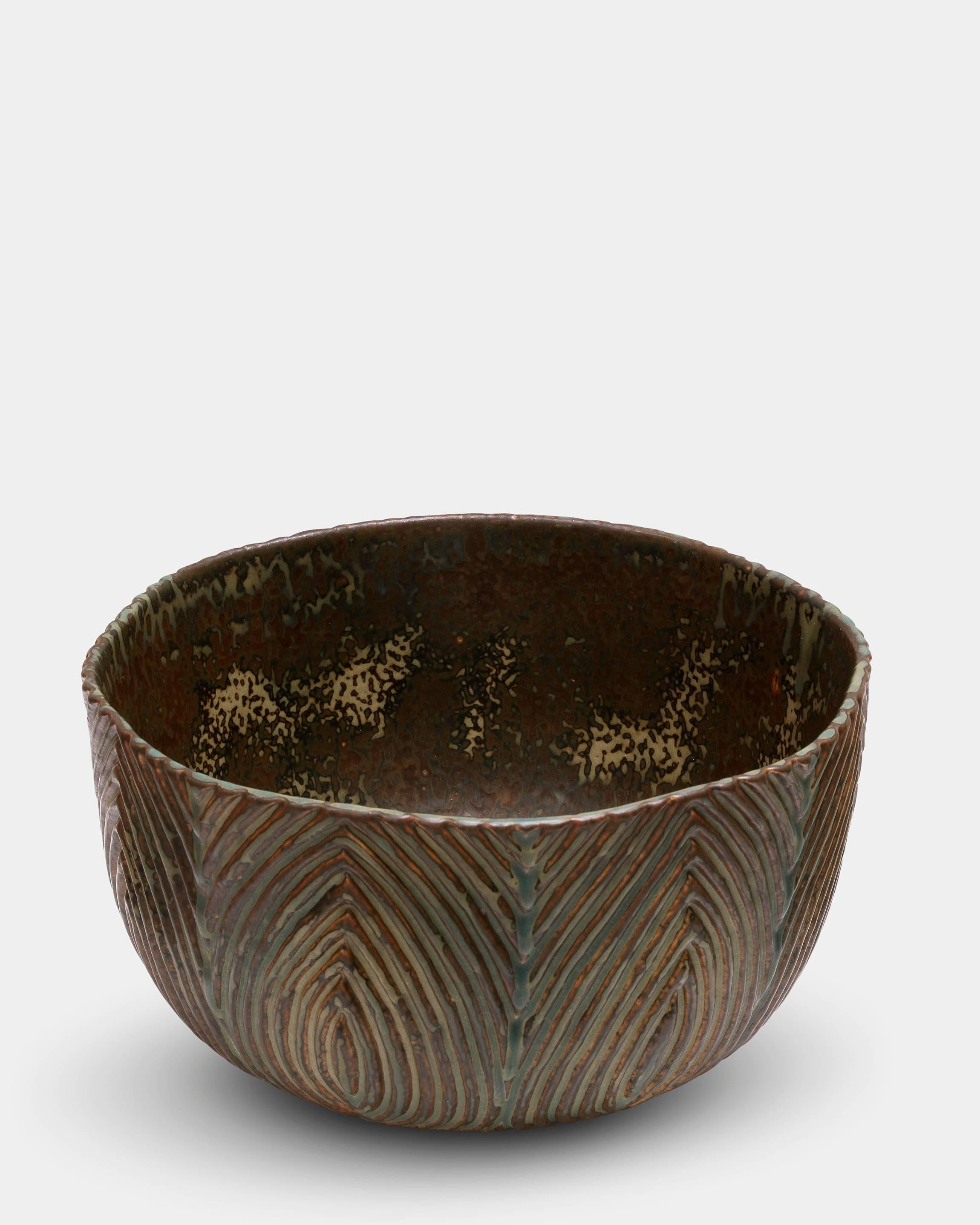 Axel Salto (1889-1961)

Large stoneware bowl by the internationally known and demanded danish ceramist Axel Salto. 
Bowl in fluted style, decorated in Sung glaze.
Manufactured in 1963 for Royal Copenhagen. Danish mid-century original vintage