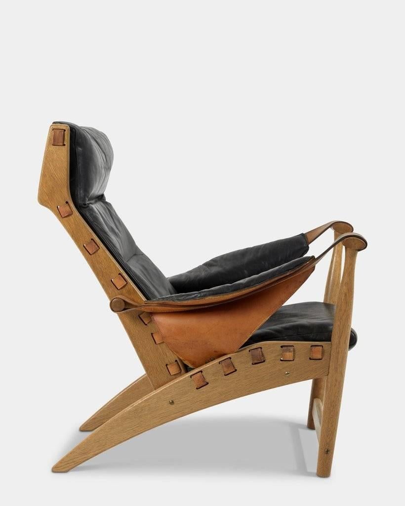 Mogens Voltelen (1908-1995): 
Copenhagen chair/Københavnerstol.
Lounge chair in oak with seat, armrests and back mounted with patinated black leather. 
Designed in 1936. Produced by Master Cabinetmaker Niels Vodder. 

Literature: 
Grethe Jalk,