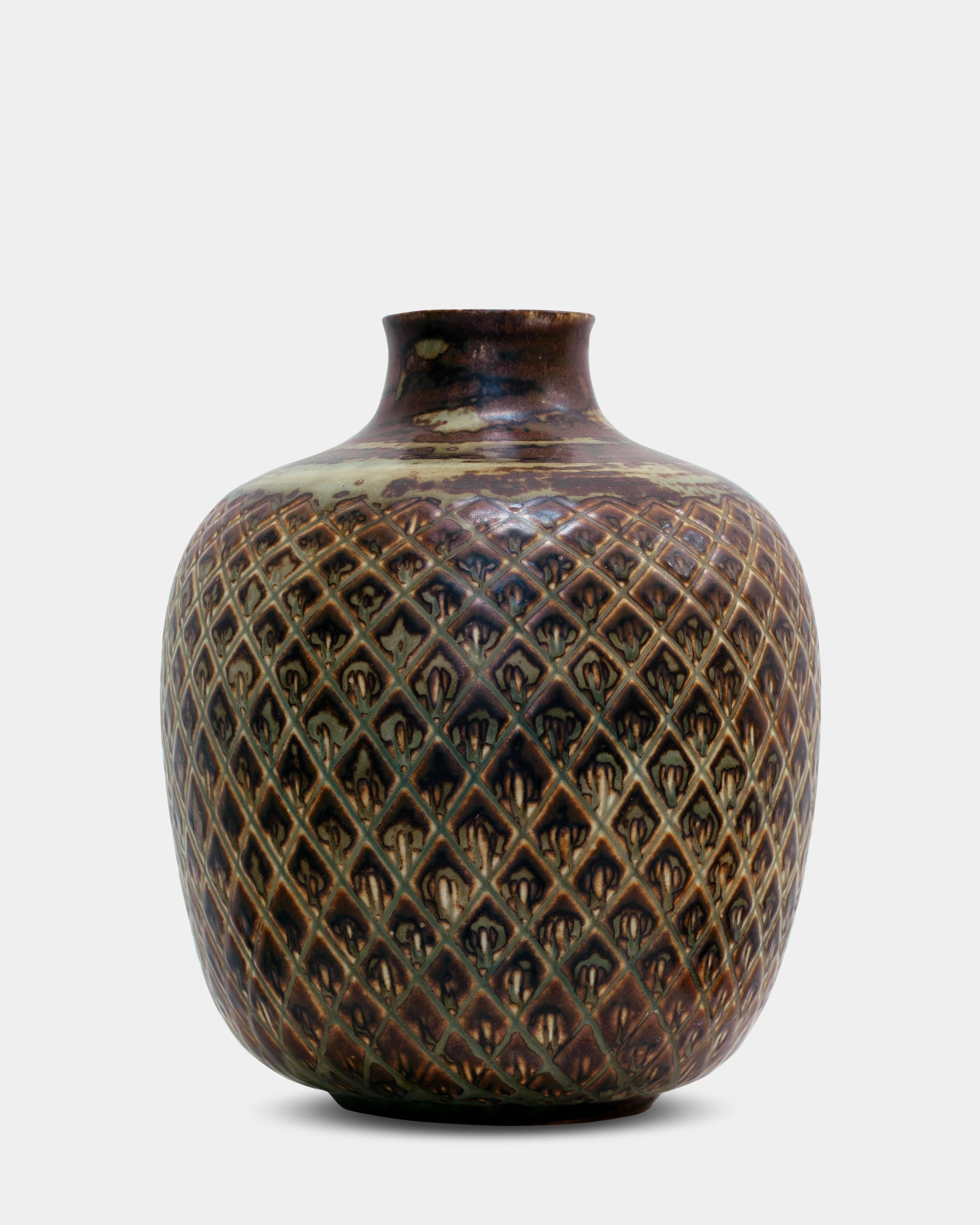 Gerd Bøgelund (1923-1987):
Glazed stoneware vase, decorated in relief. 
Signed with monogram. No. 21569, manufactured and stamped by Royal Copenhagen in 1935.

 