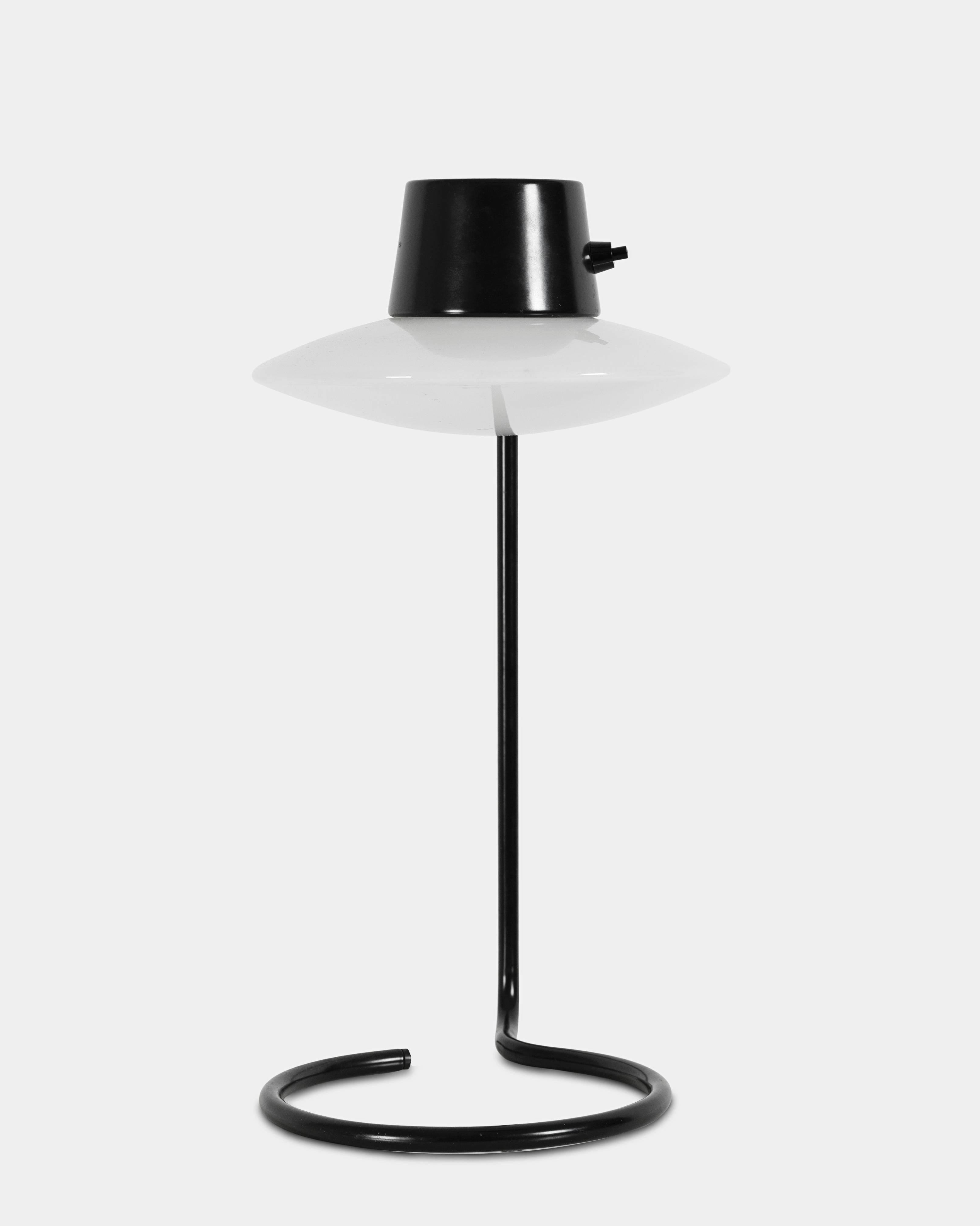 Arne Jacobsen (1902-1971):
Oxford table lamp with frame of black lacquered metal and shade of white opal glass. 
Designed 1962 for St. Catherine's College in Oxford. 
Manufactured by Louis Poulsen.
 